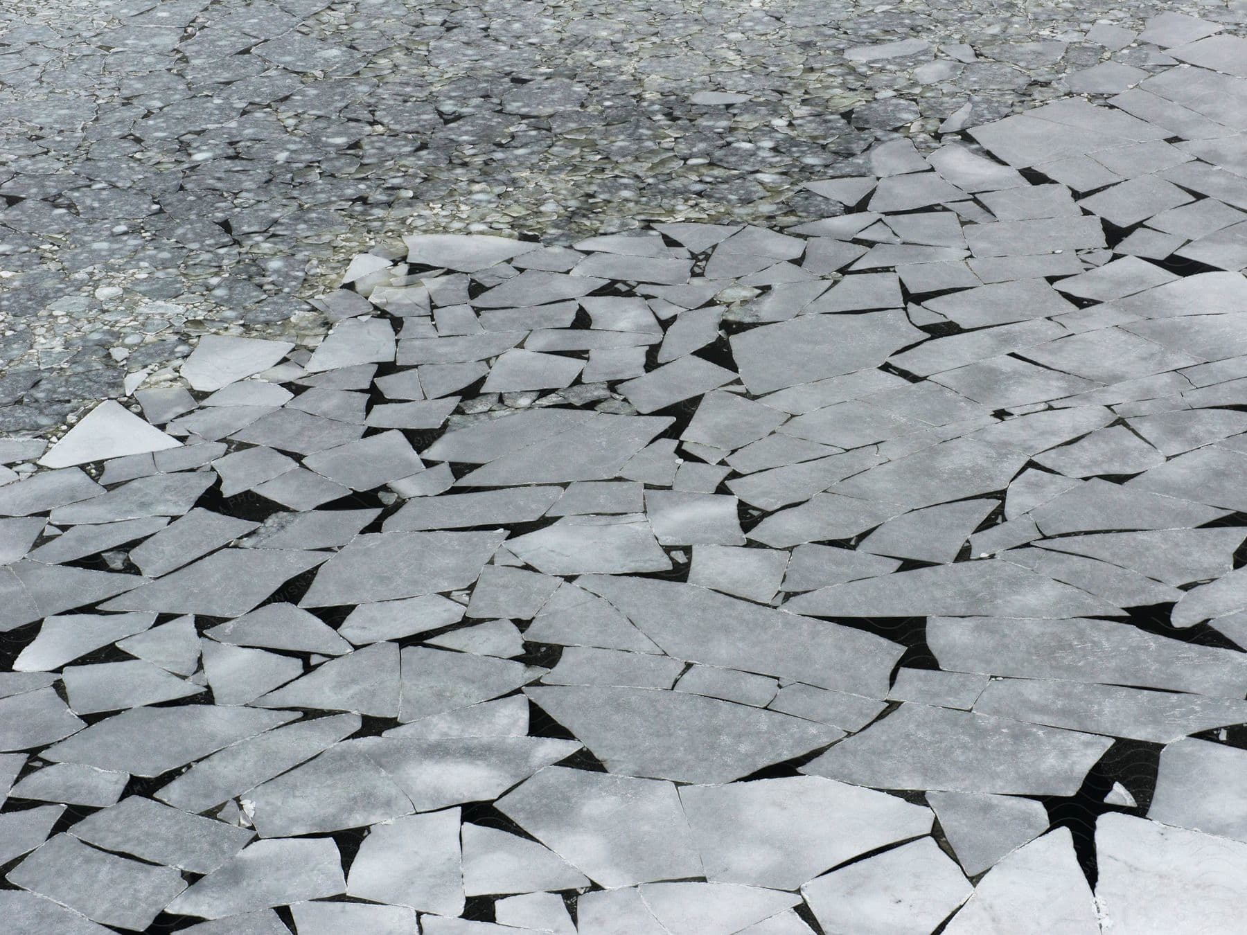 Ice broke into pieces on a paved surface