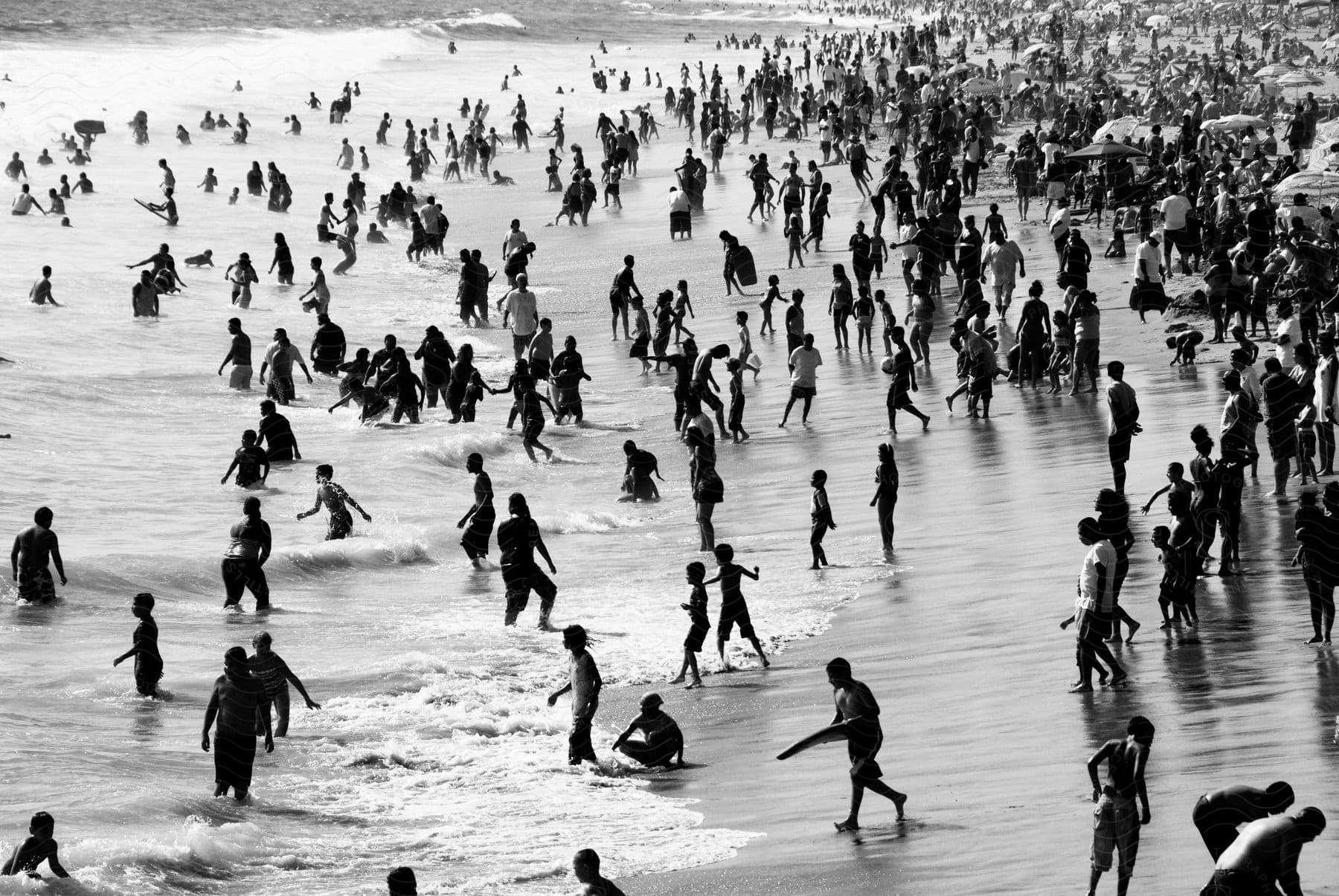 People playing and frolicking on the beach in black and white