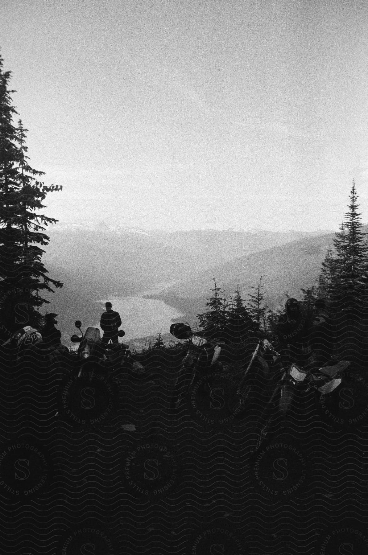 Group of people on dirt road with mountains and lake in the background