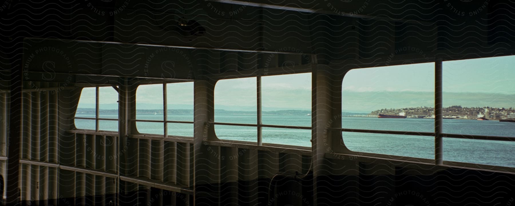 Inside view of a ship with windows overlooking water shorelines and towns on the waterfront