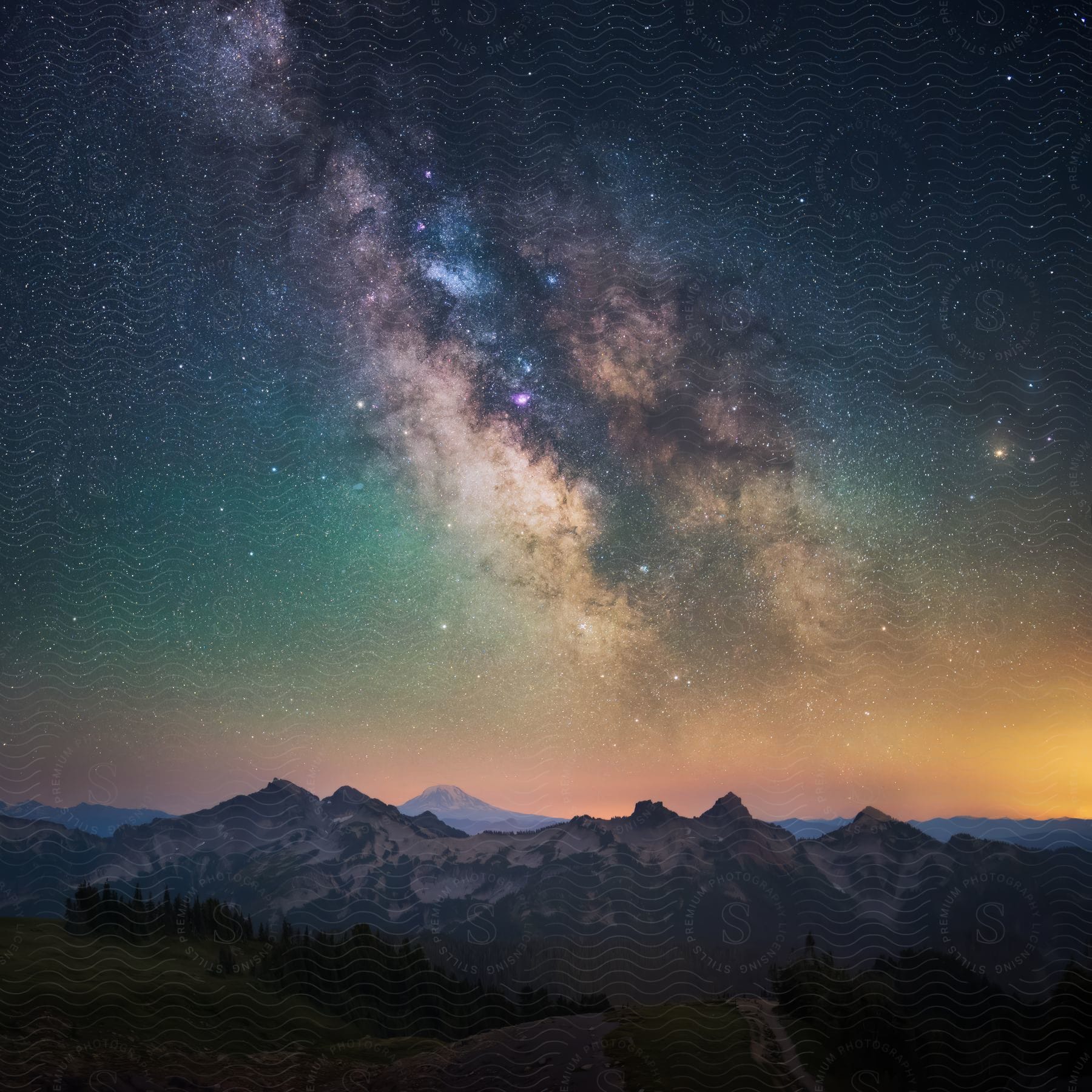 Mountain range and hills under a starry sky resembling the northern lights