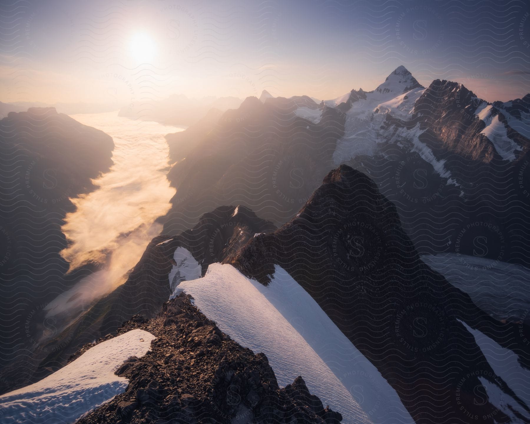 Snow covered mountains under a blue sky with sunlight