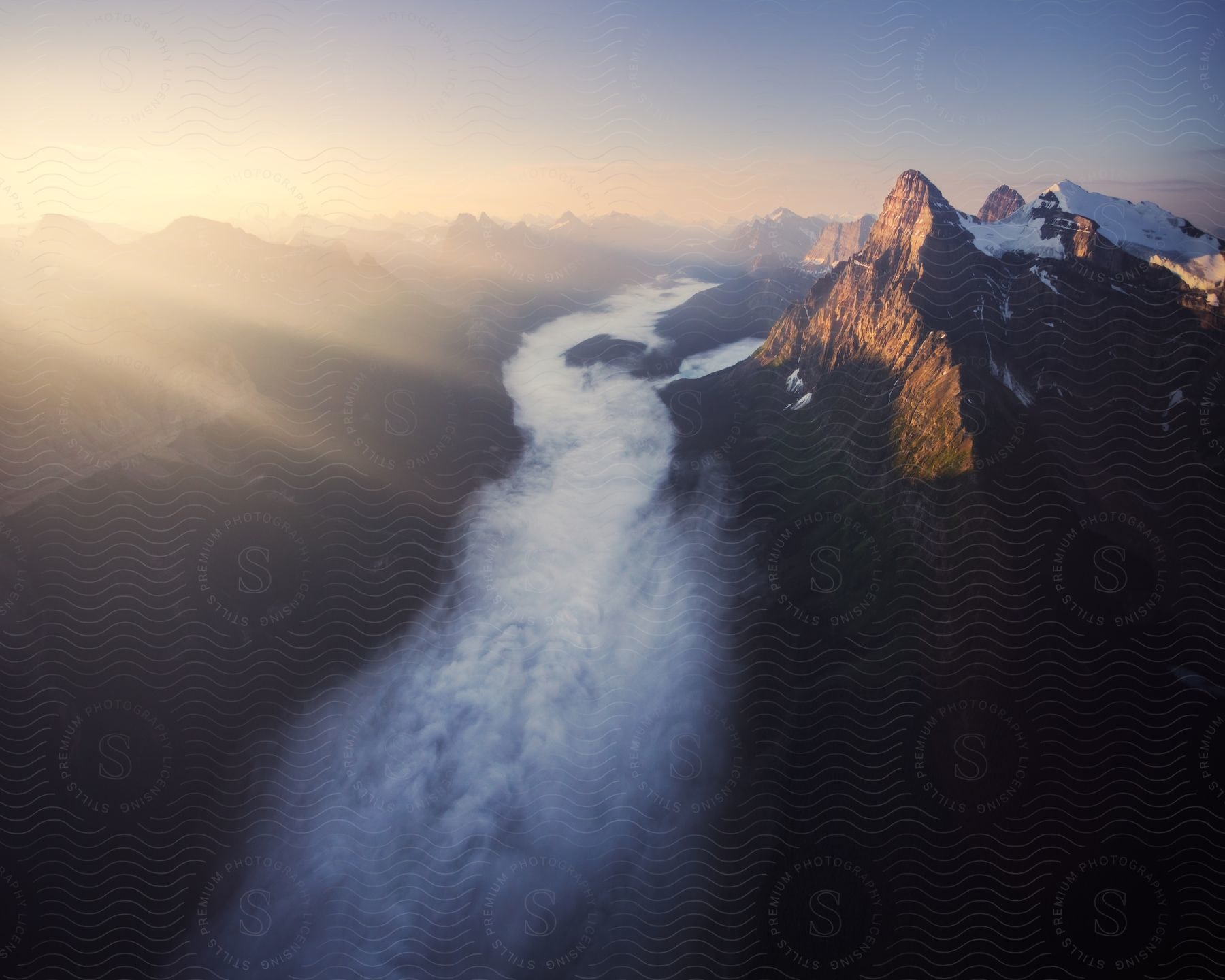 Mountains at sunrise with a river of fog