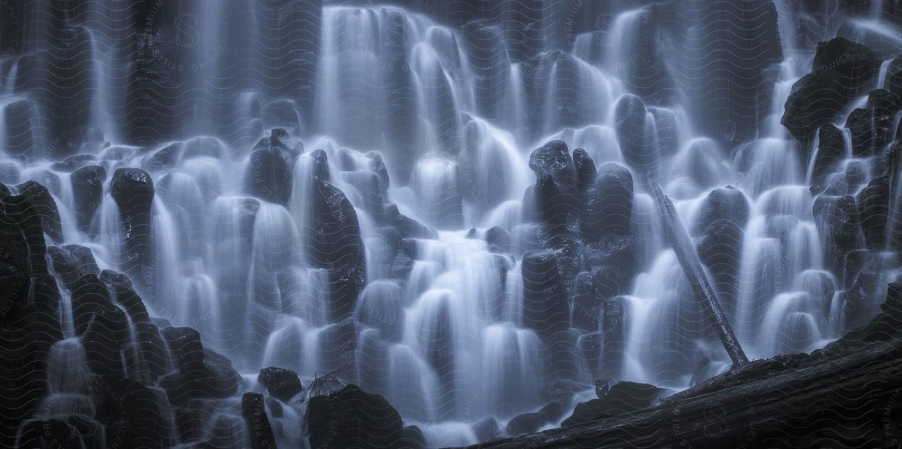 Blue glowing waterfalls inside cavern in oregon