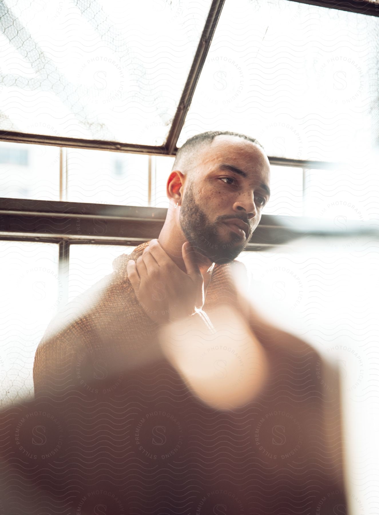 A man standing in a room next to a window