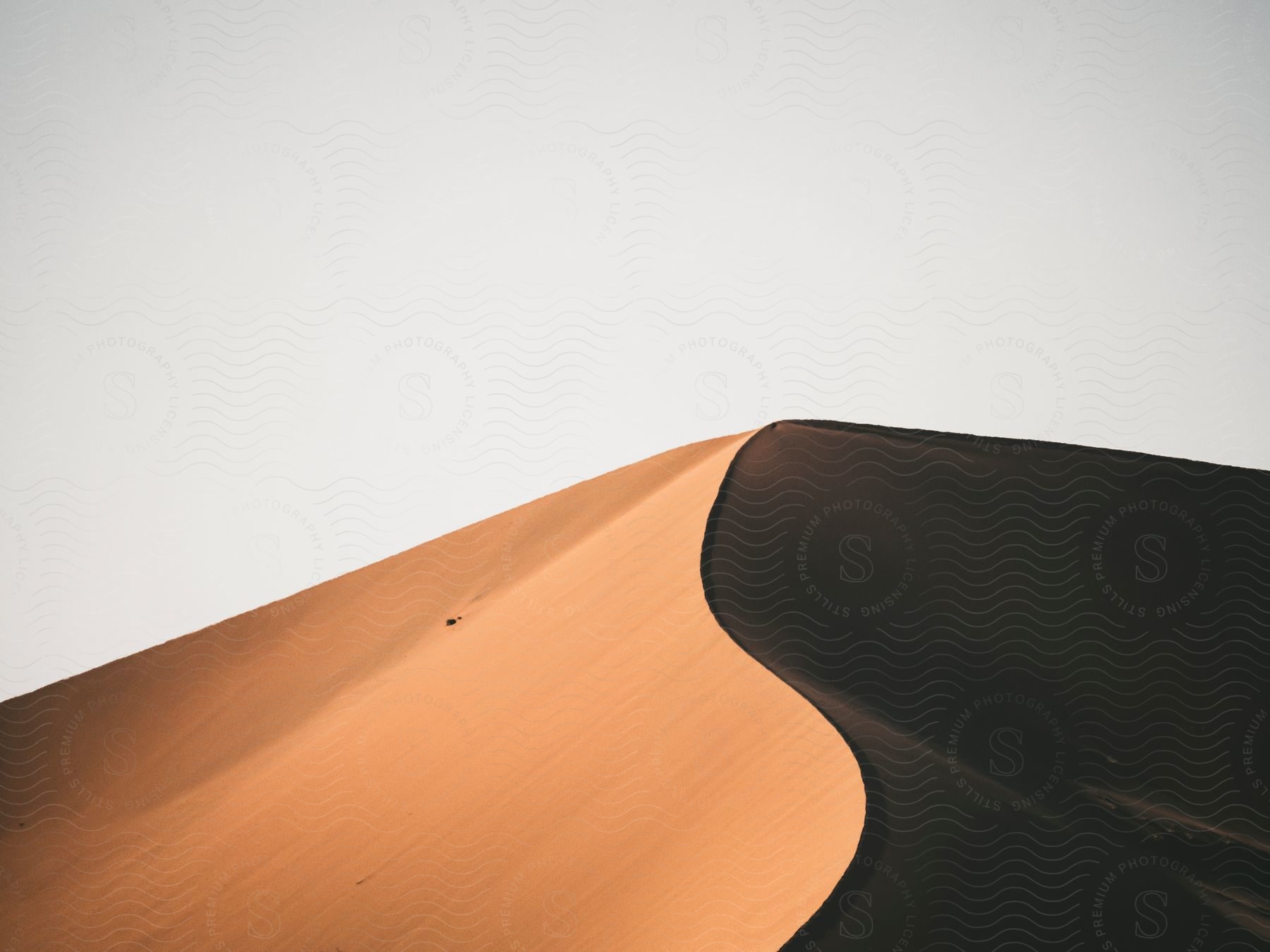 A sand dune with half in light and half in shadow