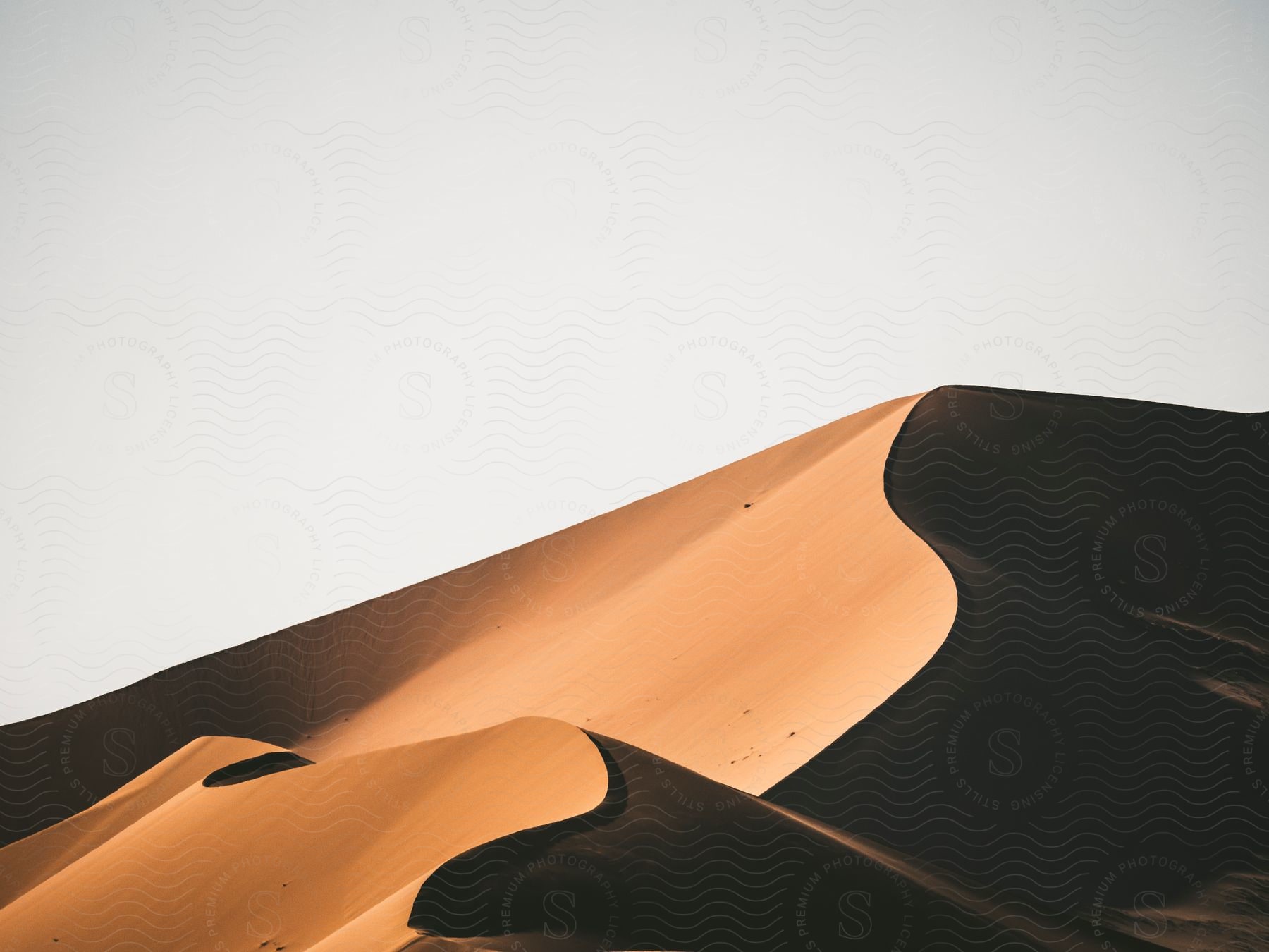 A barren desert landscape with sand dunes stretching towards the horizon