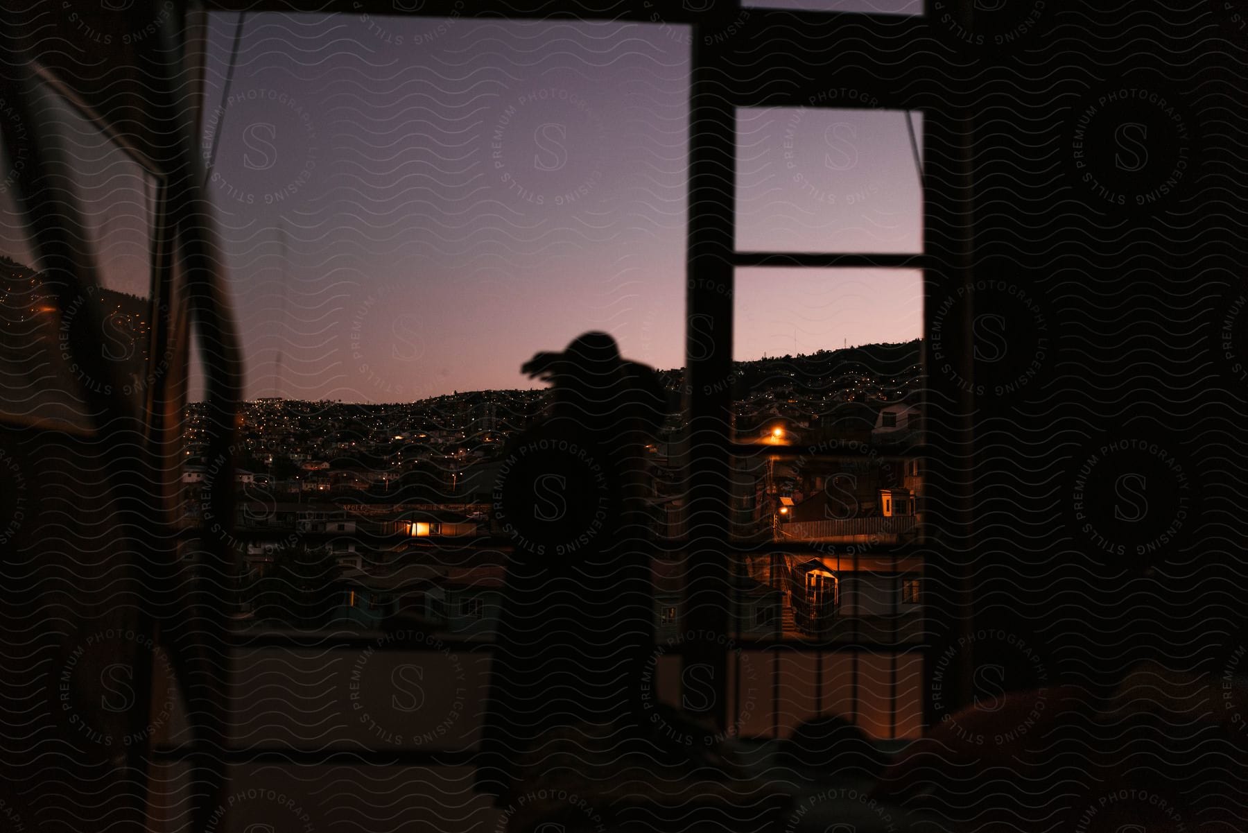 A person on a balcony overlooking a city at dusk