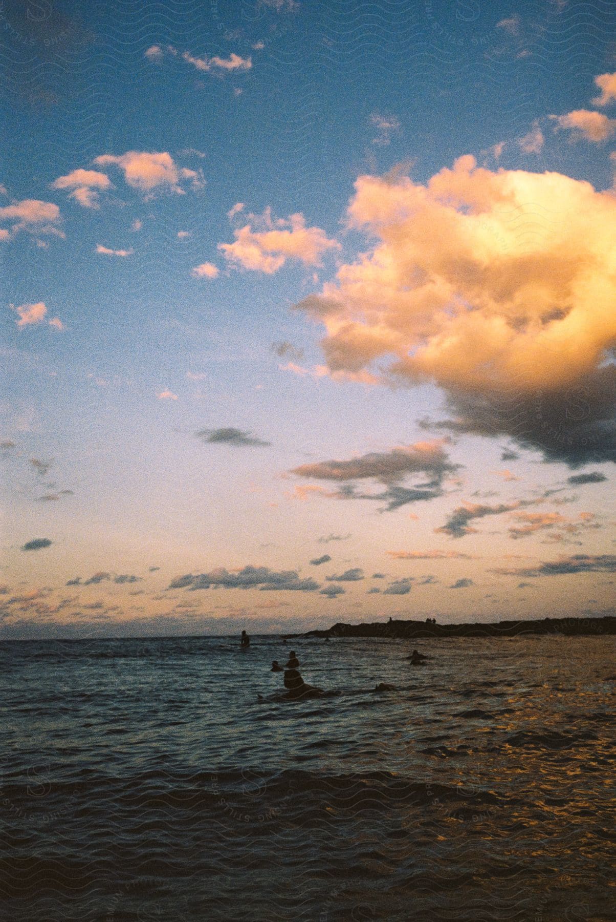 A small group of people on a boat in a scenic outdoor setting with a lake and sky