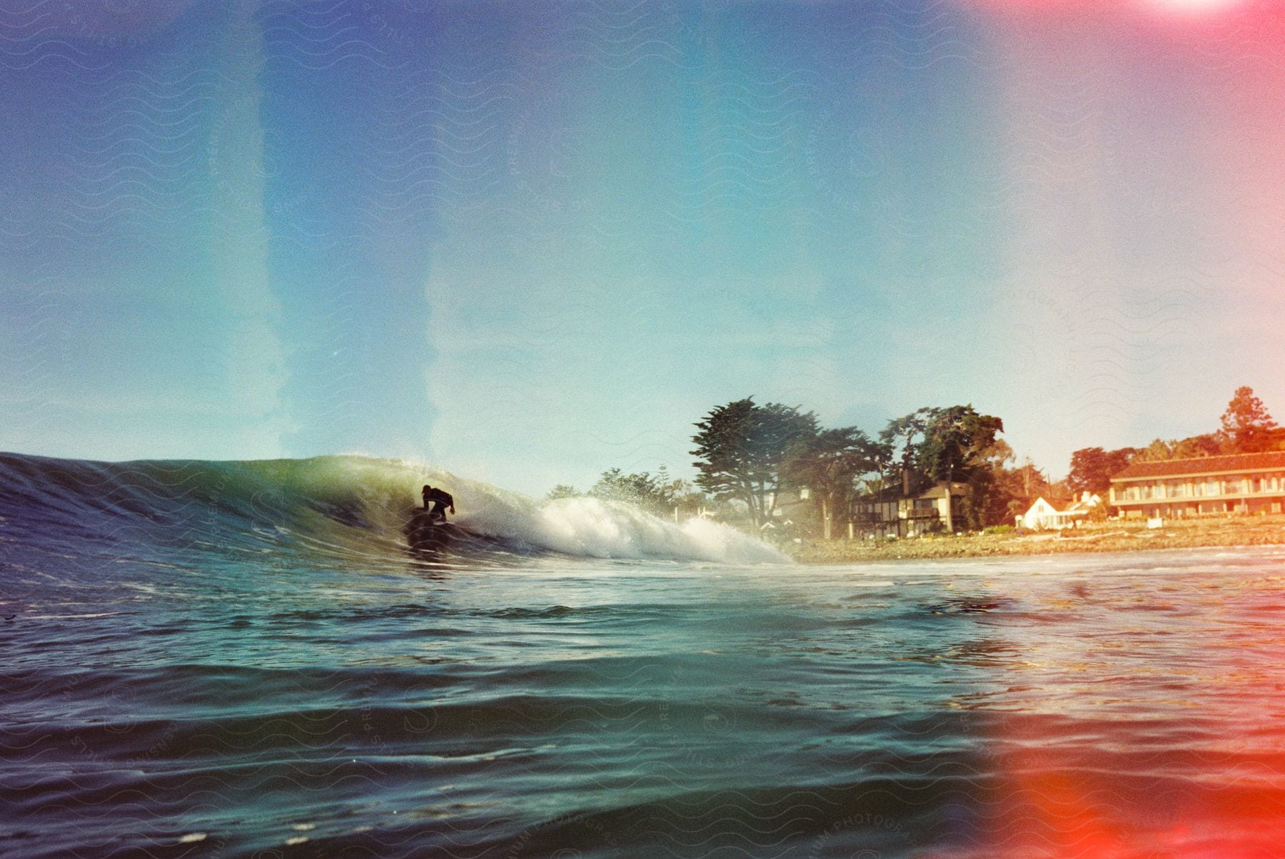 A person surfs on a big wave in a double exposed photo