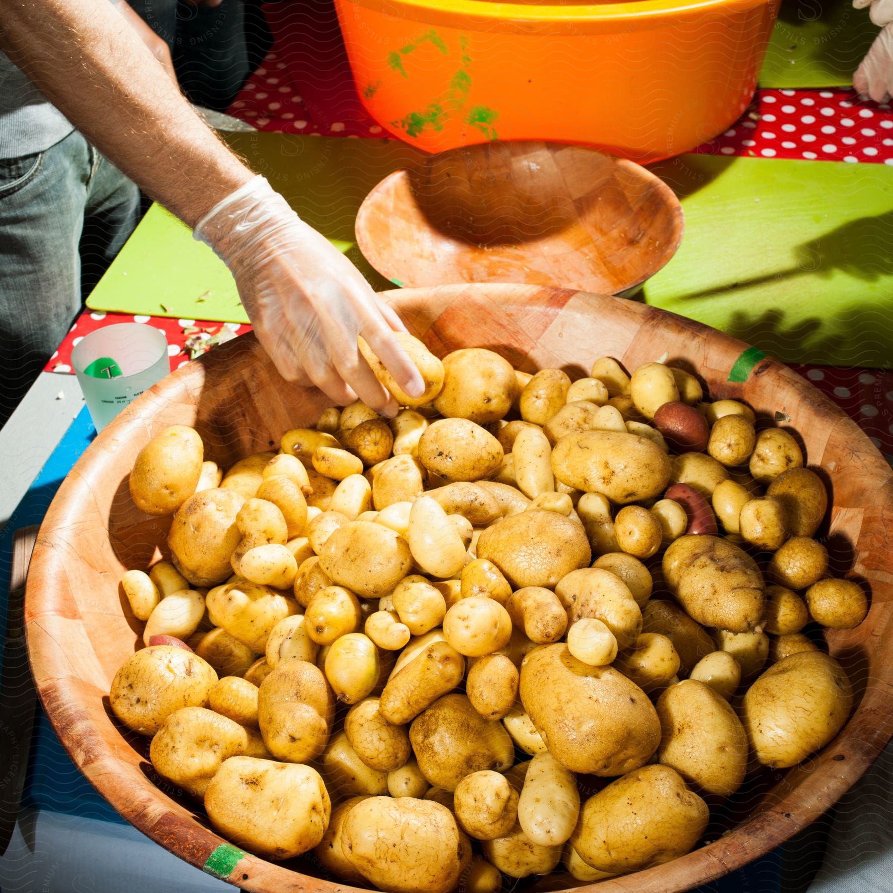 A man takes a potato from a bowl