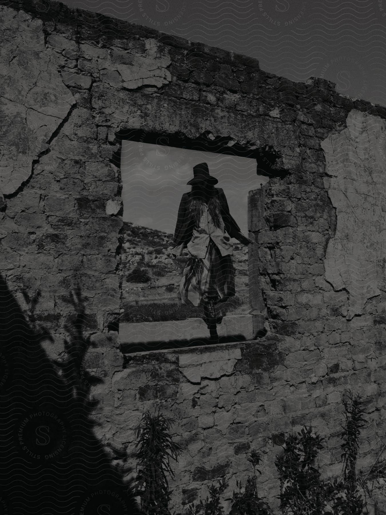 A man walking towards a severely damaged and ruined building