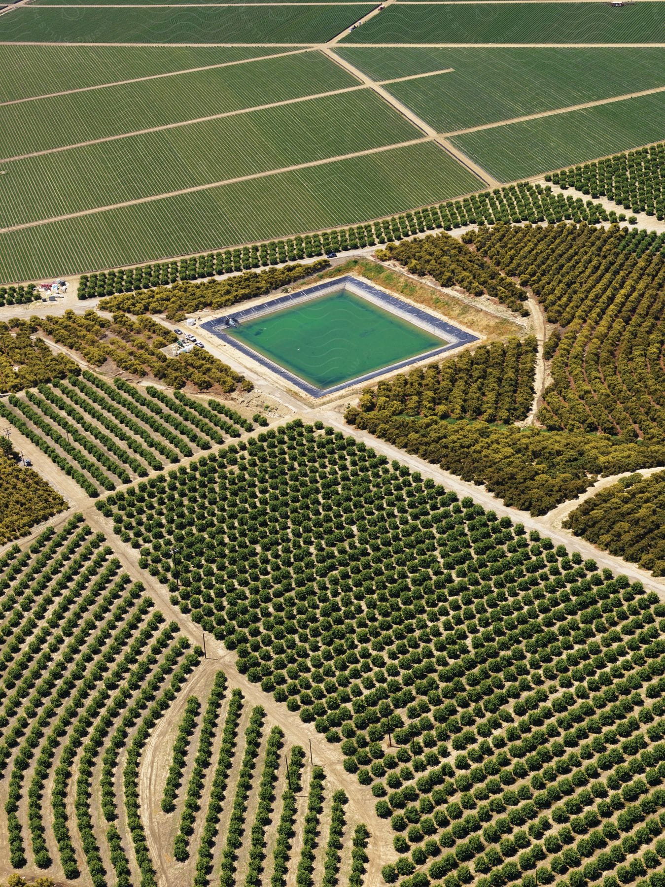 Stock photo of farmland plots surrounding a reservoir in an aerial view