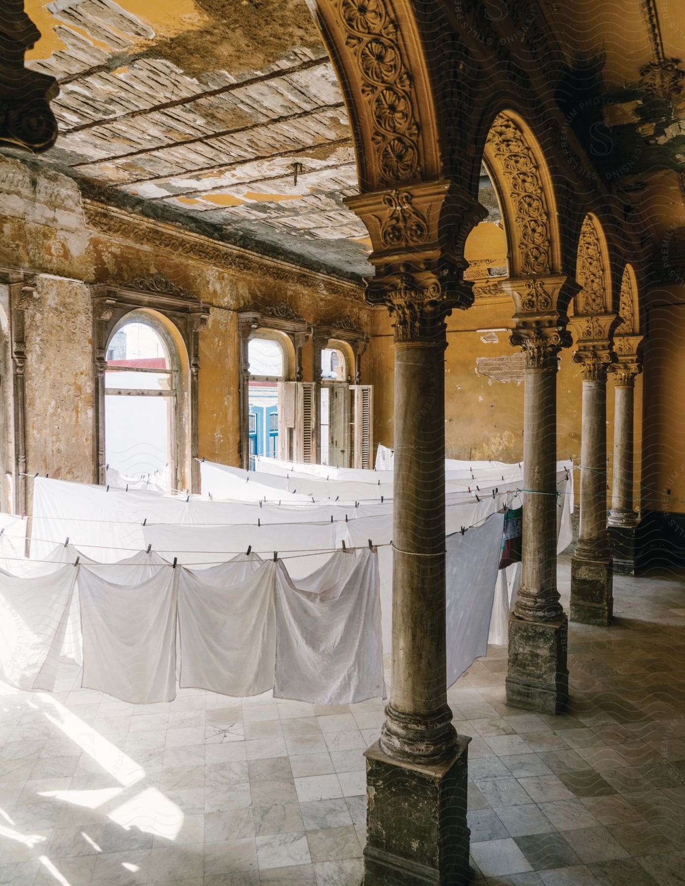 Bed sheets hanging to dry in a room inside a classical style building