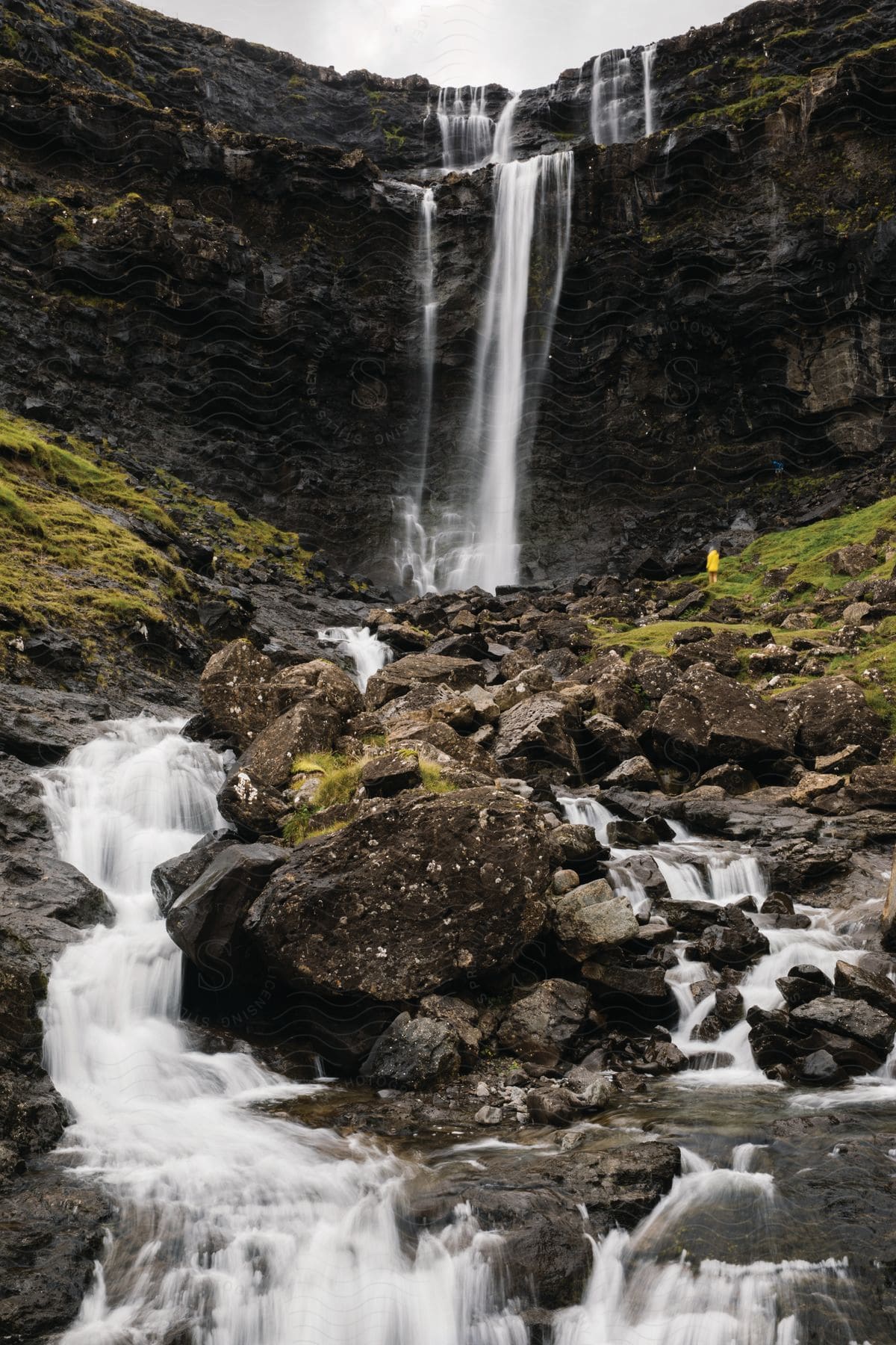 A waterfall cascades down a rocky cliff in a natural outdoor setting