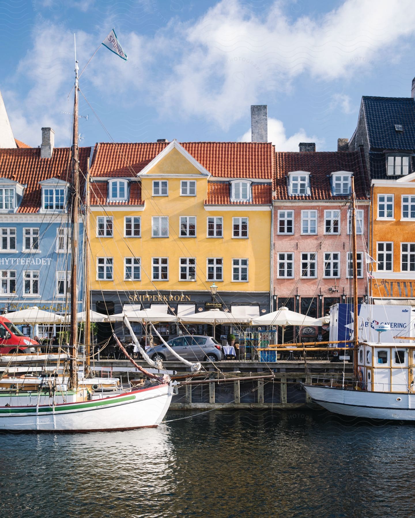 Boats tied to a pier next to historic residential buildings