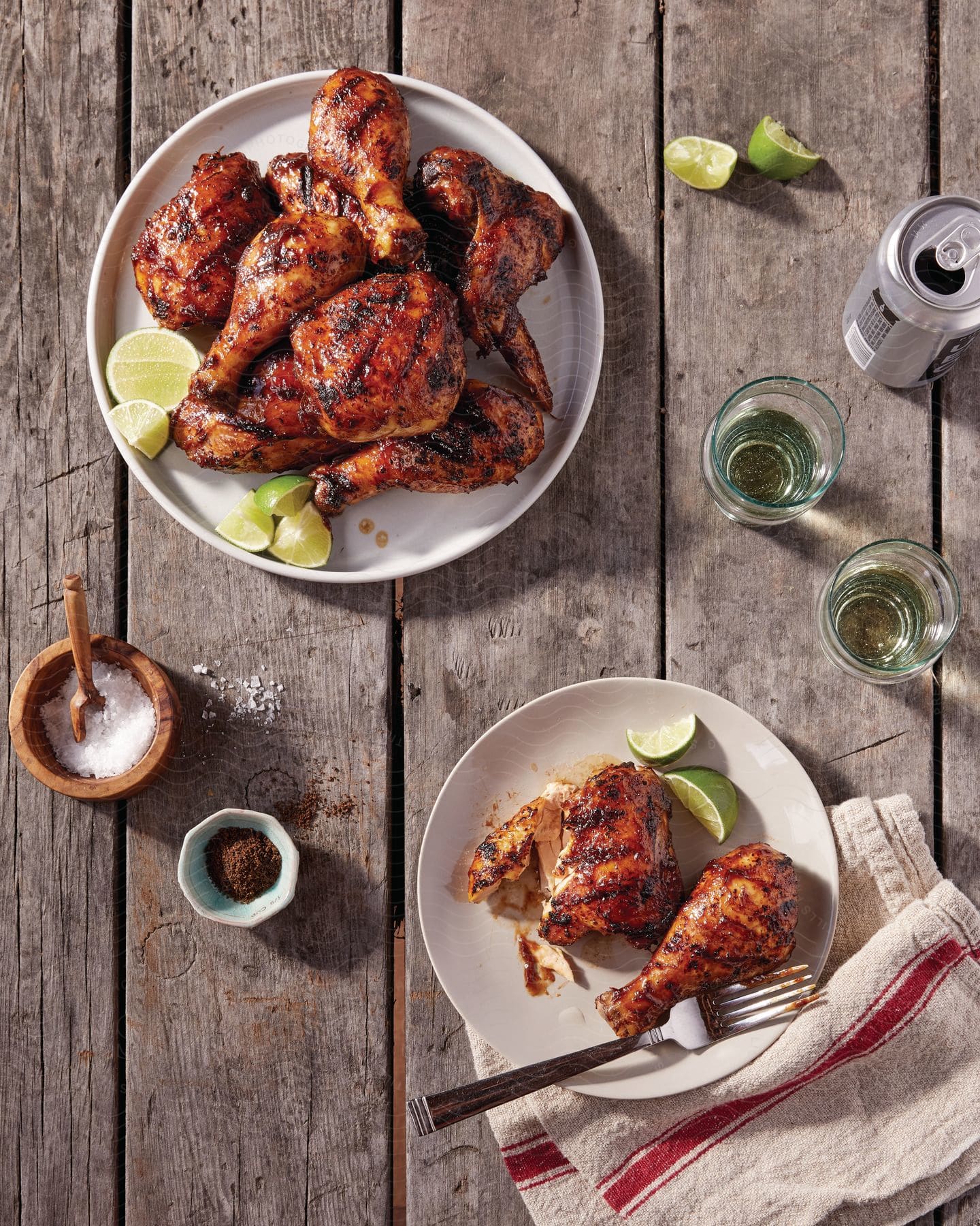 Grilled chicken with lime on a platter surrounded by drinks and ingredients