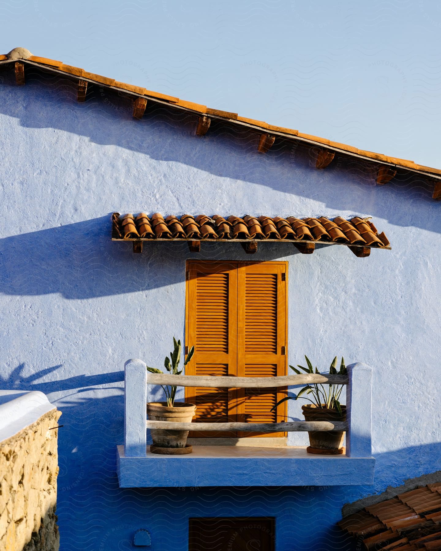 Wooden doors leading to a house from a porch with potted plants