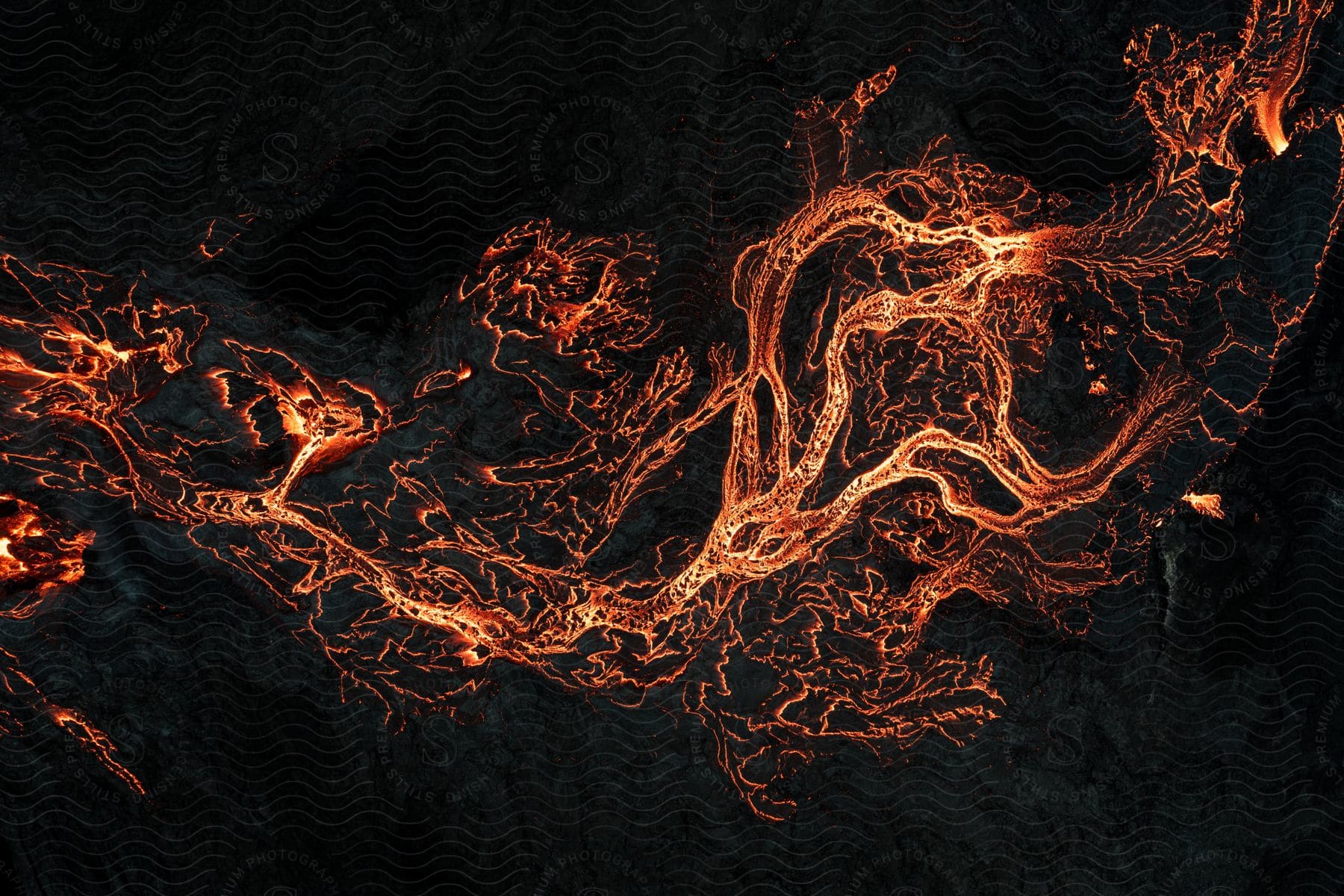 Aerial view of lava spreading over the land at night time