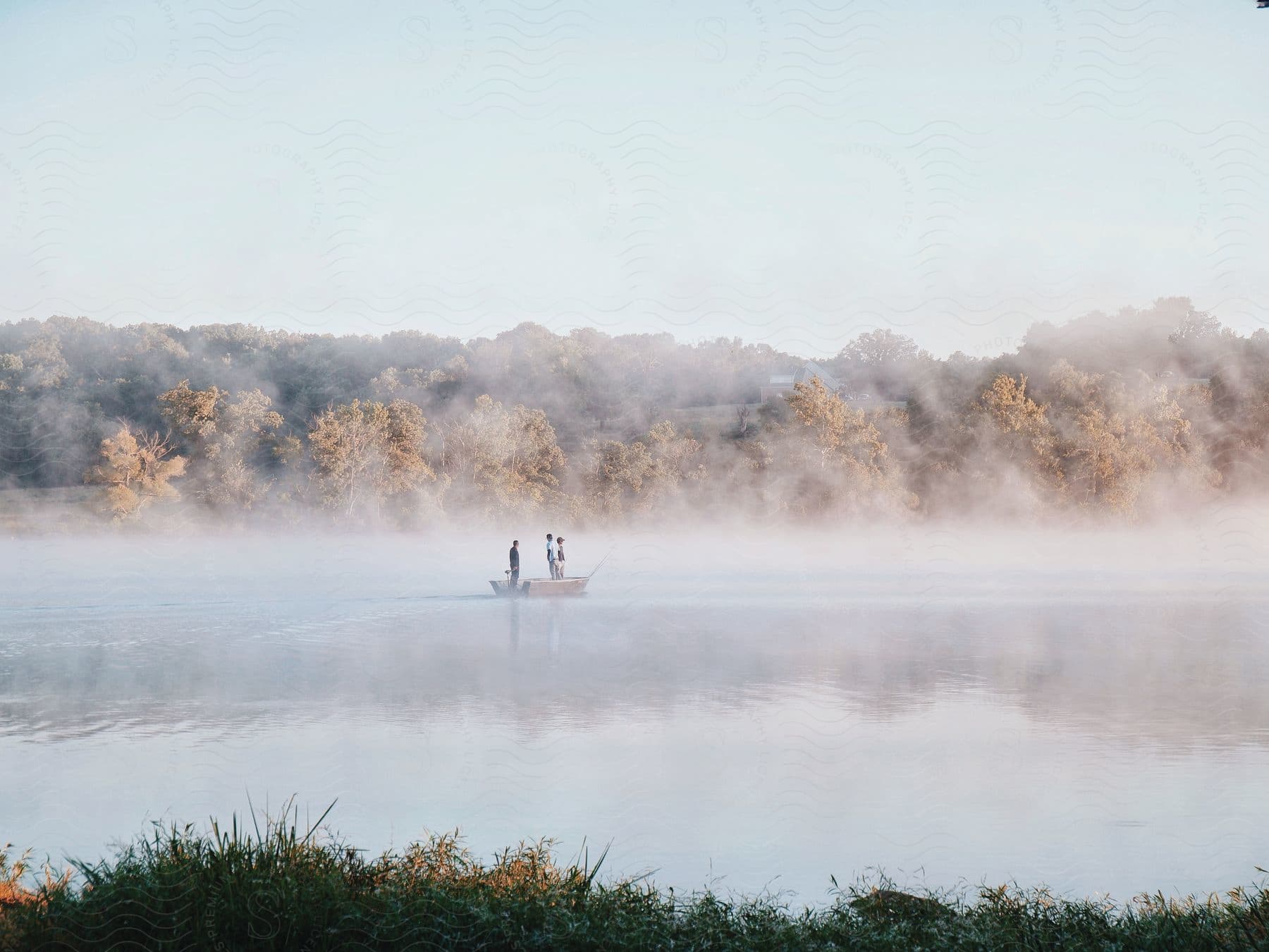 People rowing in a foggy lake