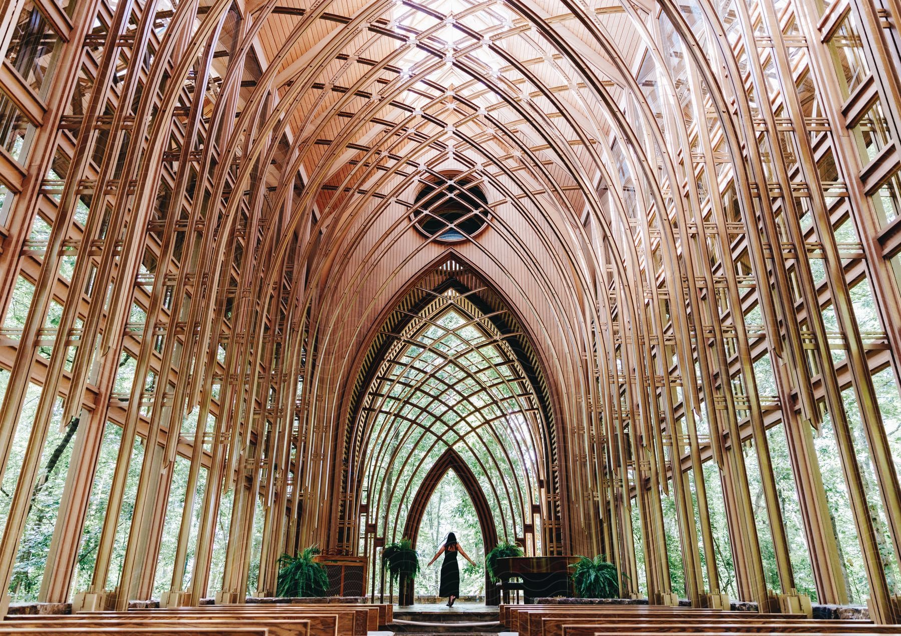 An arched chapel with metal intertwining frame between glass windows on a sunny day