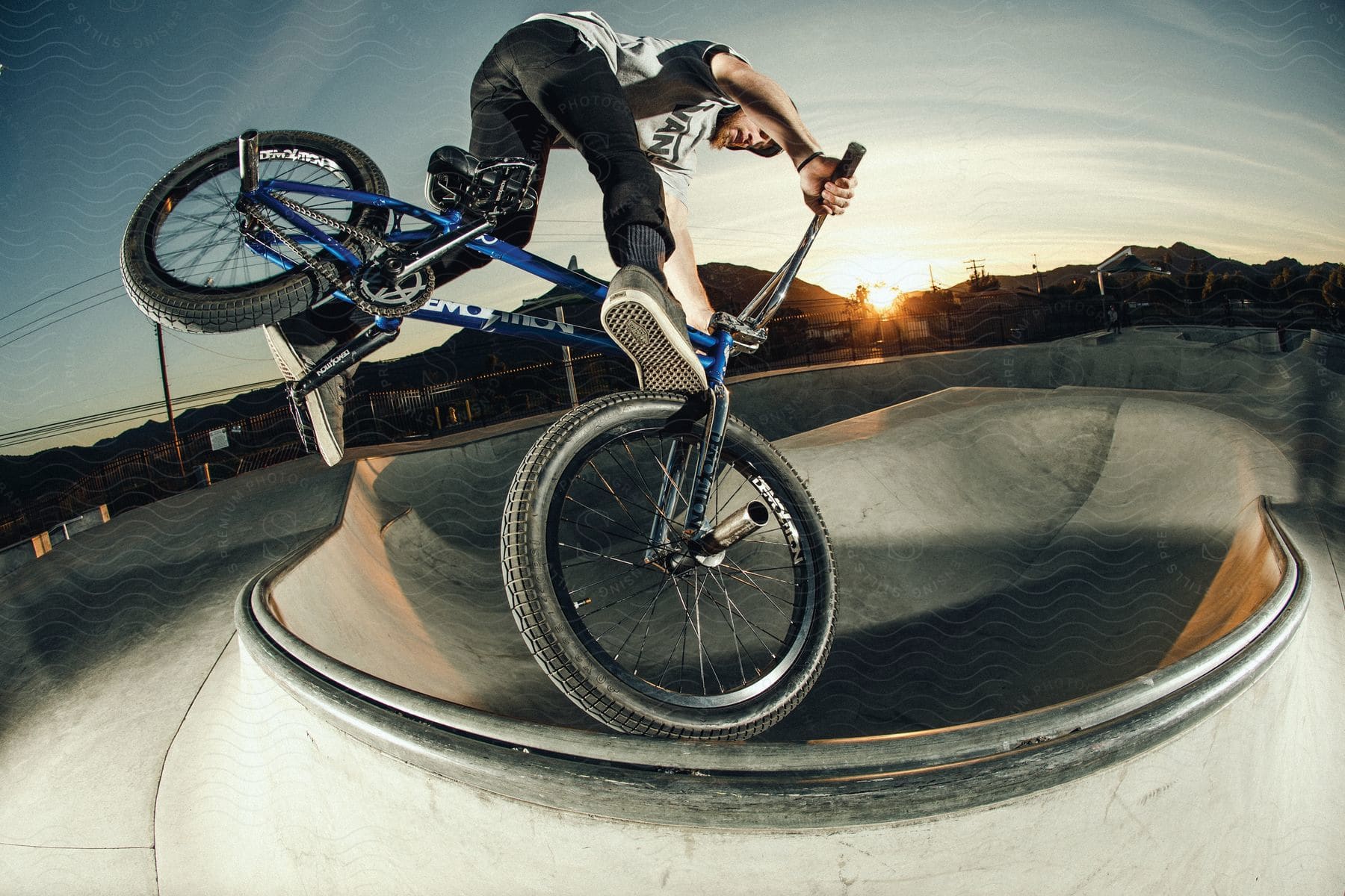 A person performing a stunt on a bmx bike outdoors at dusk or dawn