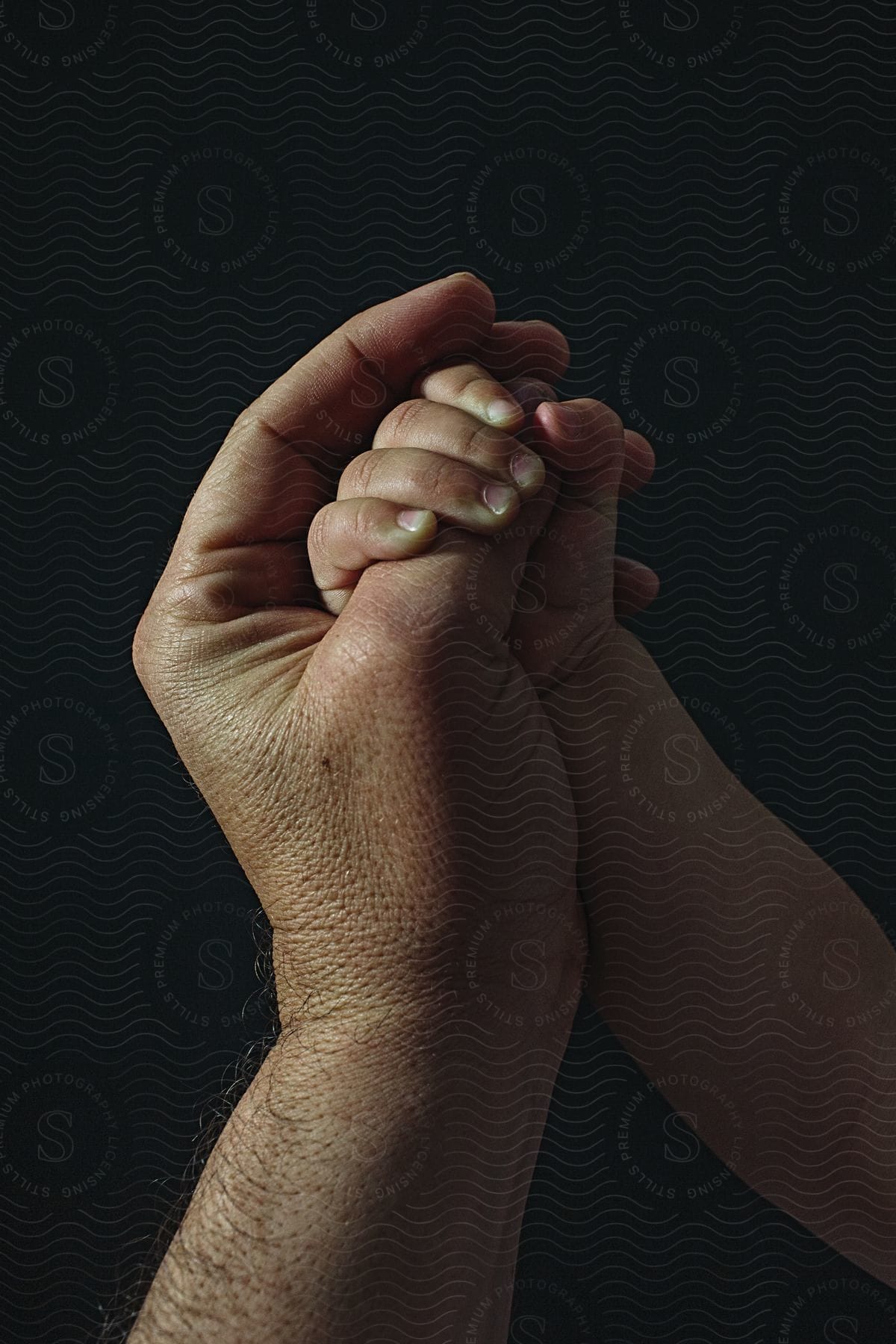 A newborns hand grasping a fathers thumb