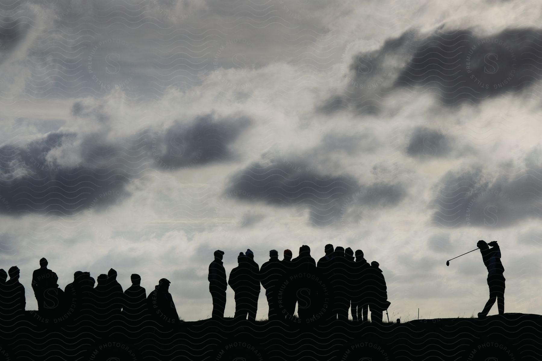 Many people on a golf course on a cloudy day