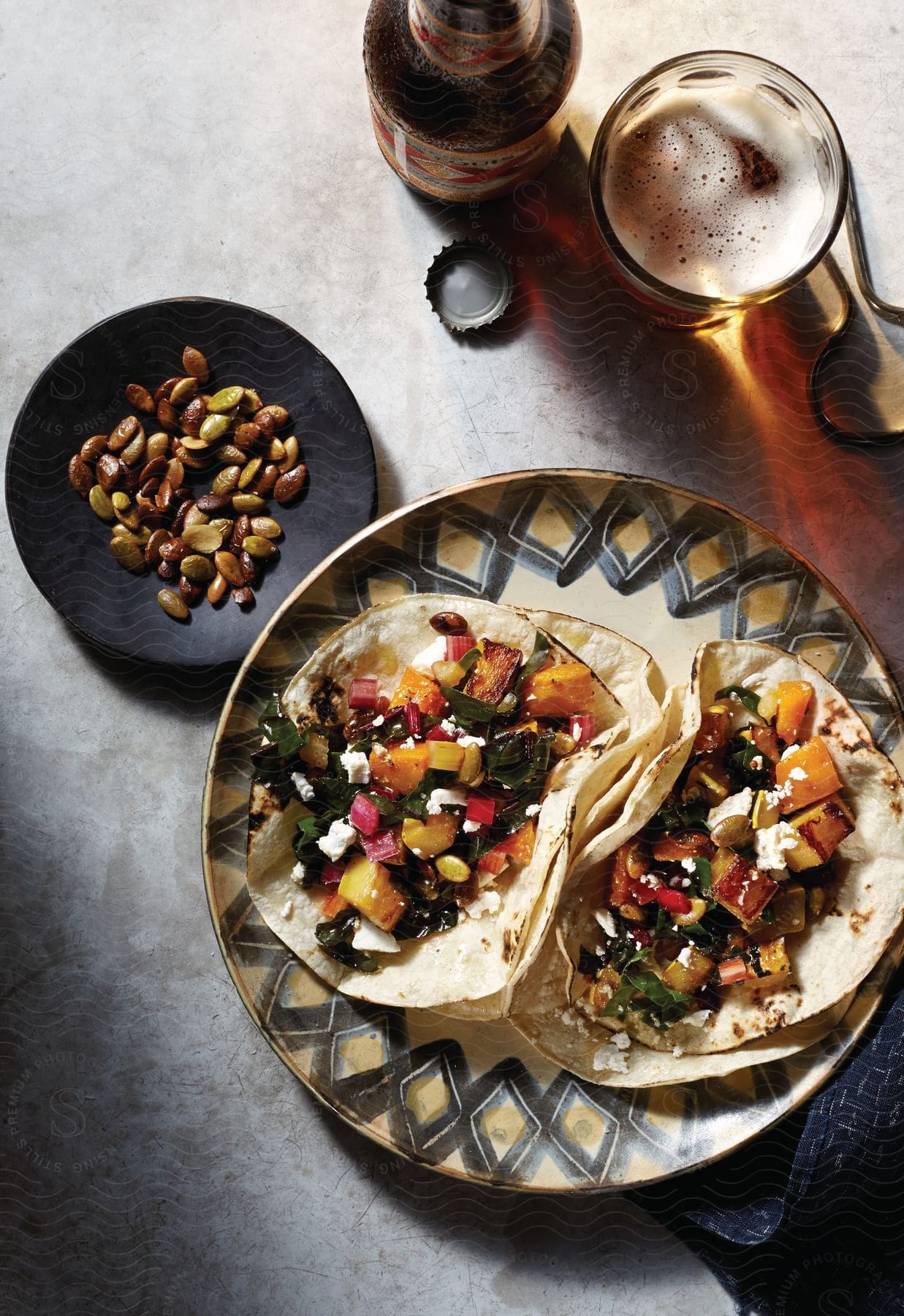 Plate with traditional food and a bottle and glass of beer on top of a table