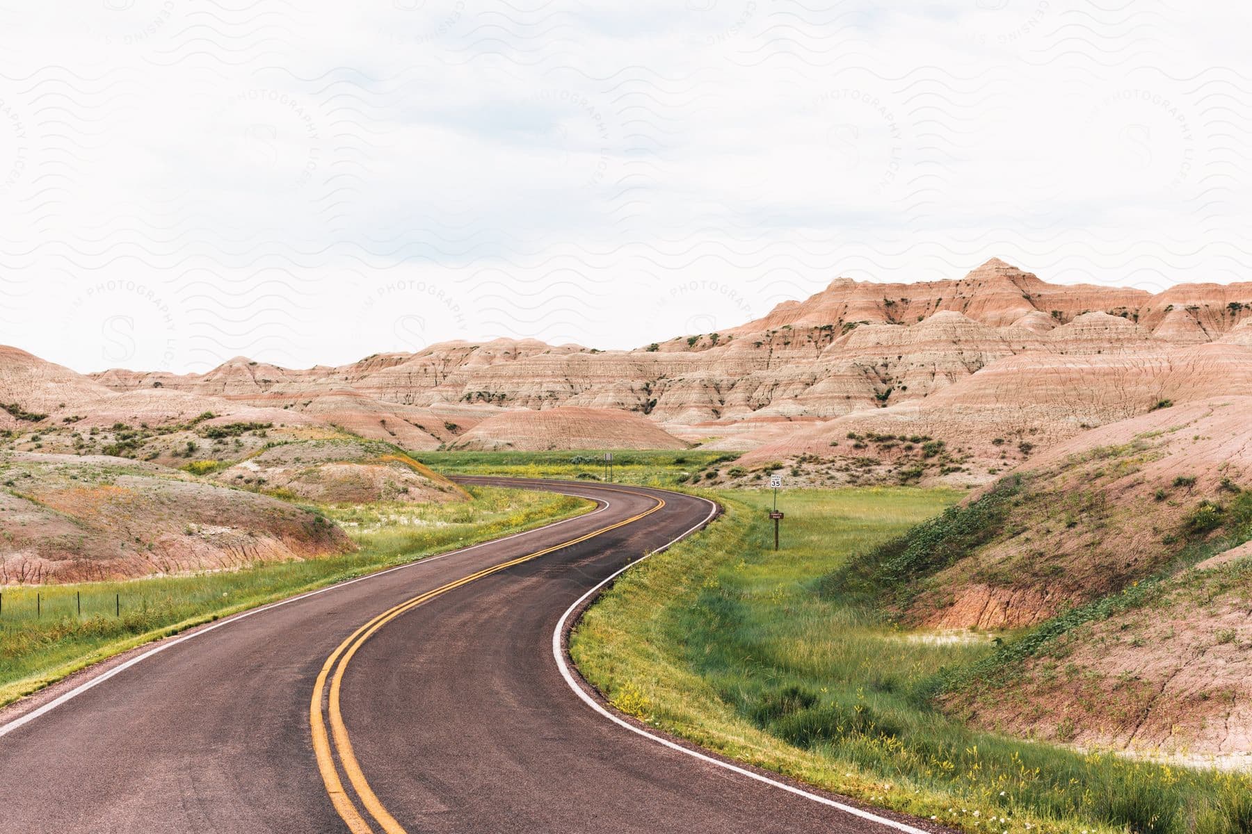 A wild landscape with a desert road and mountains