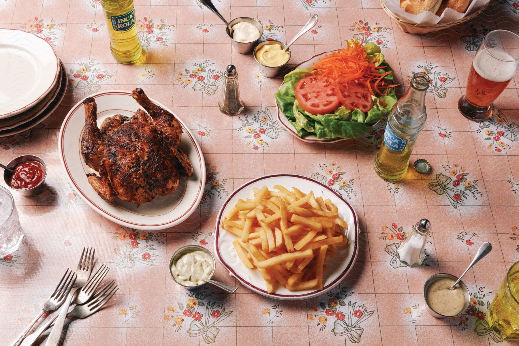 Roast chicken french fries vegetables and various condiments on a table