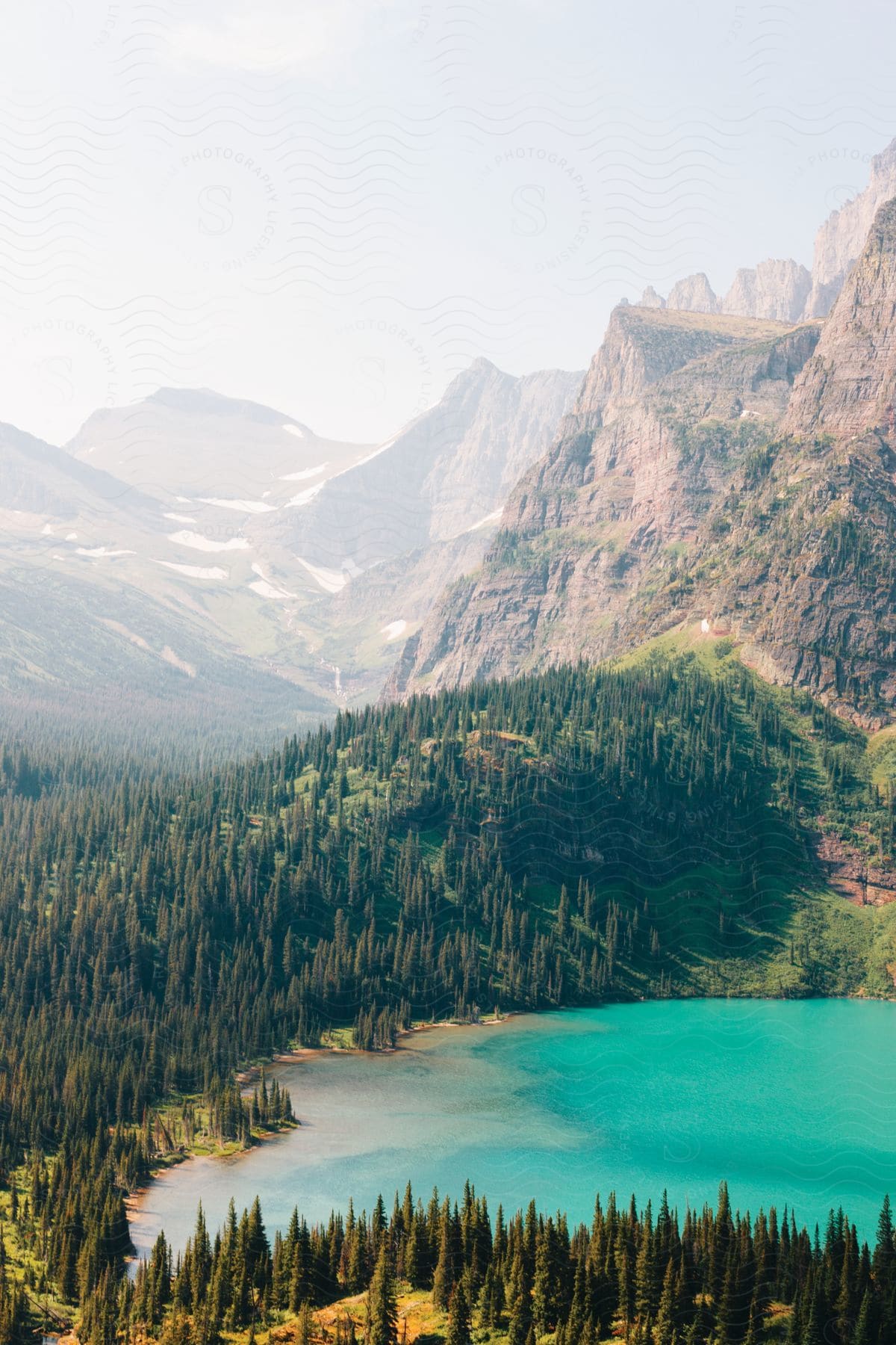 Aerial view of a small turquoise colored mountain lake in a forested surroundings