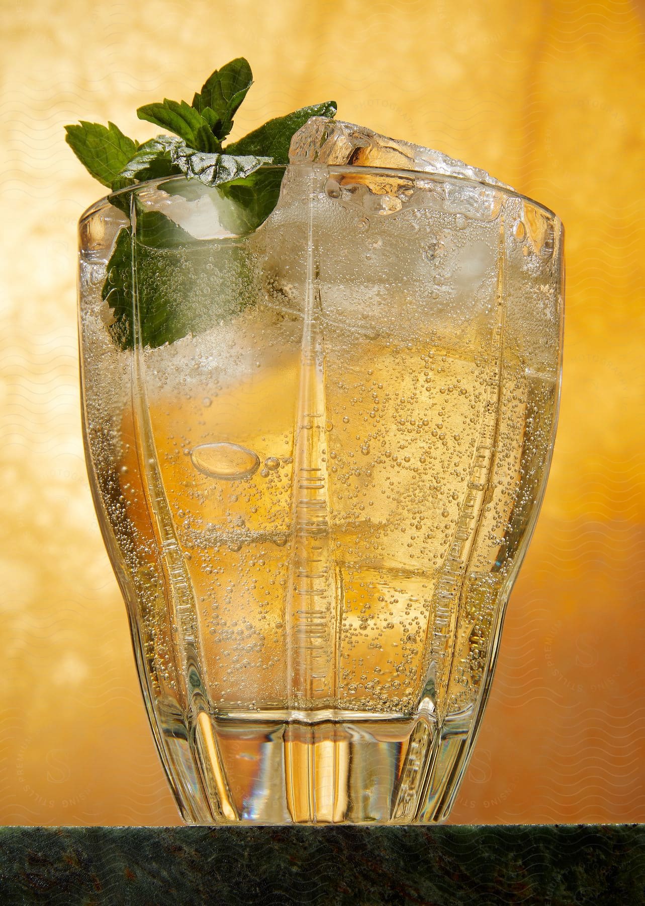 A glass of sparkling drink with ice and mint