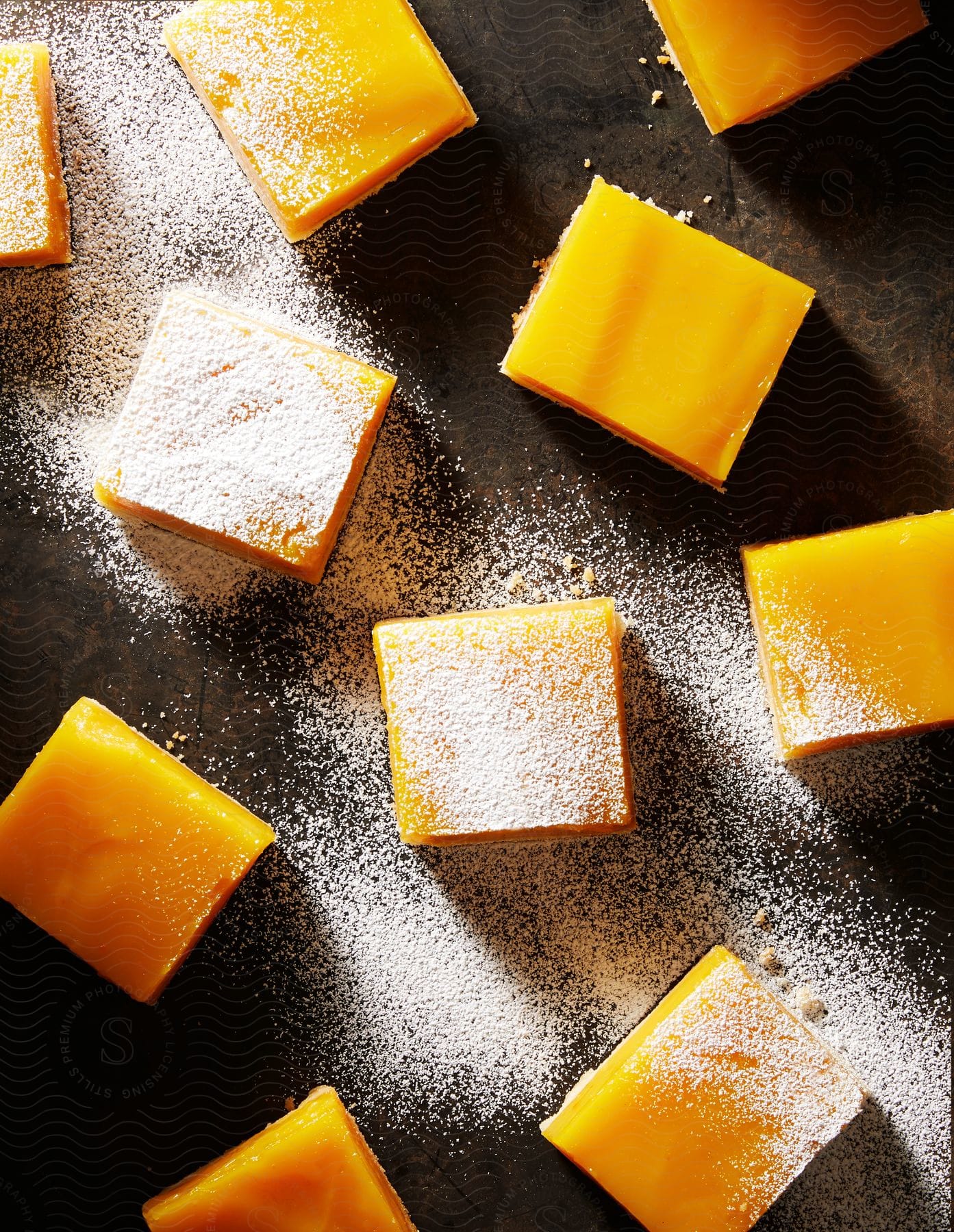 Several crackercut slices of cheese are arranged with powder sugar in still life