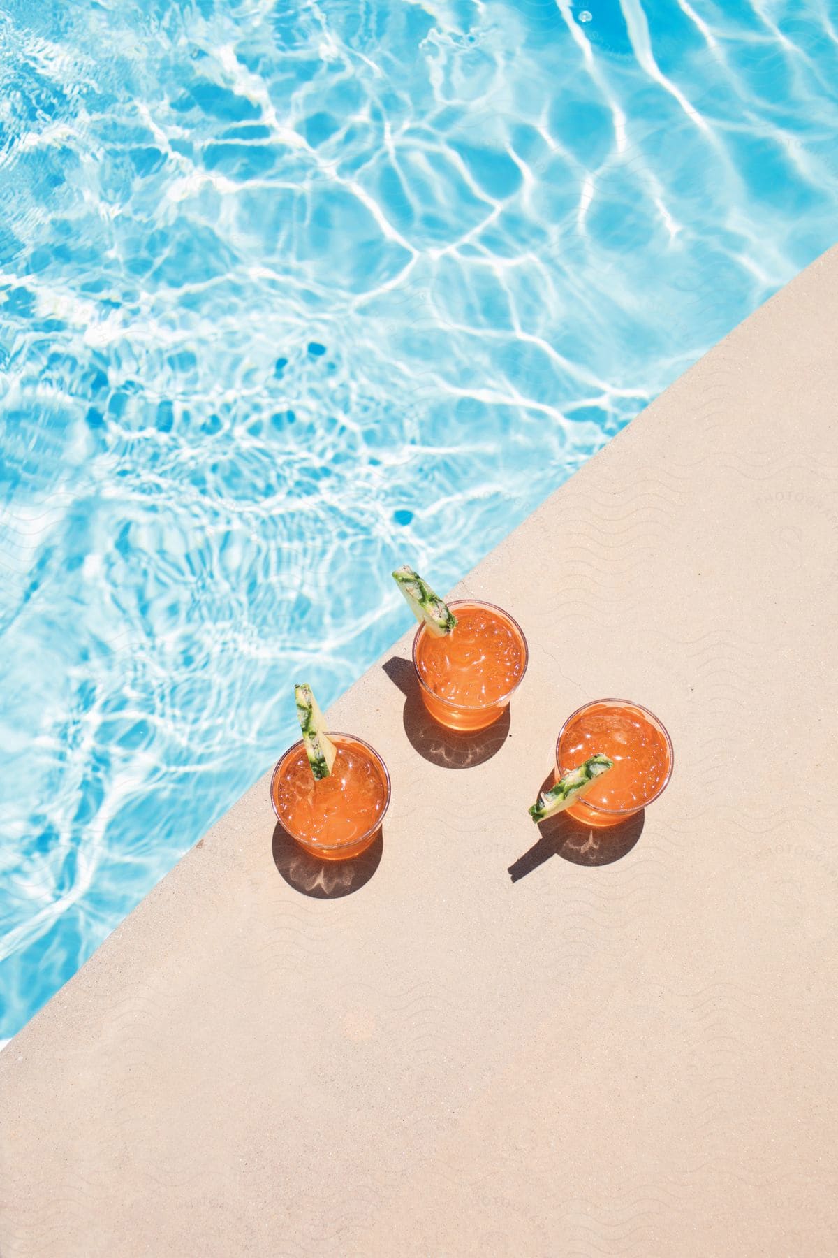 Stock photo of three cocktails by a pool