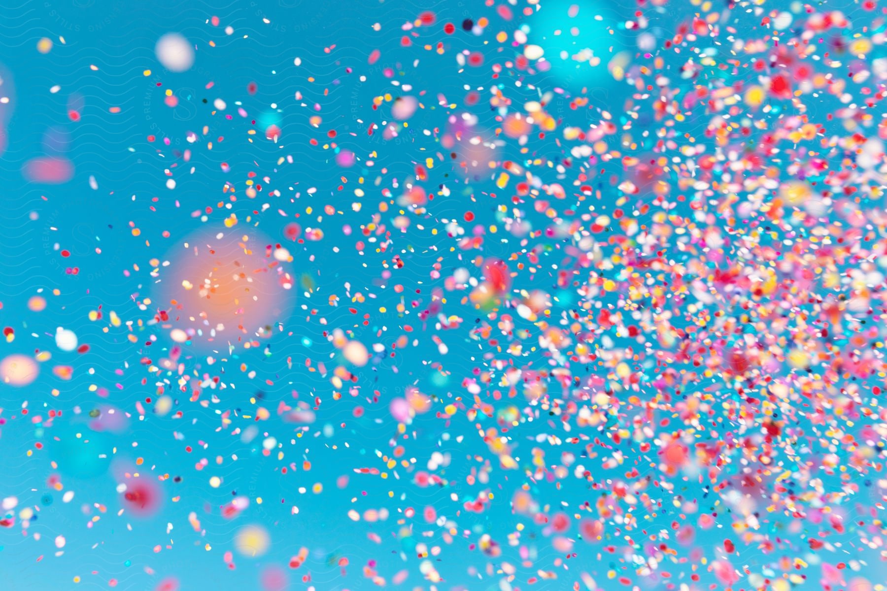 Multicolored particles against a light blue background