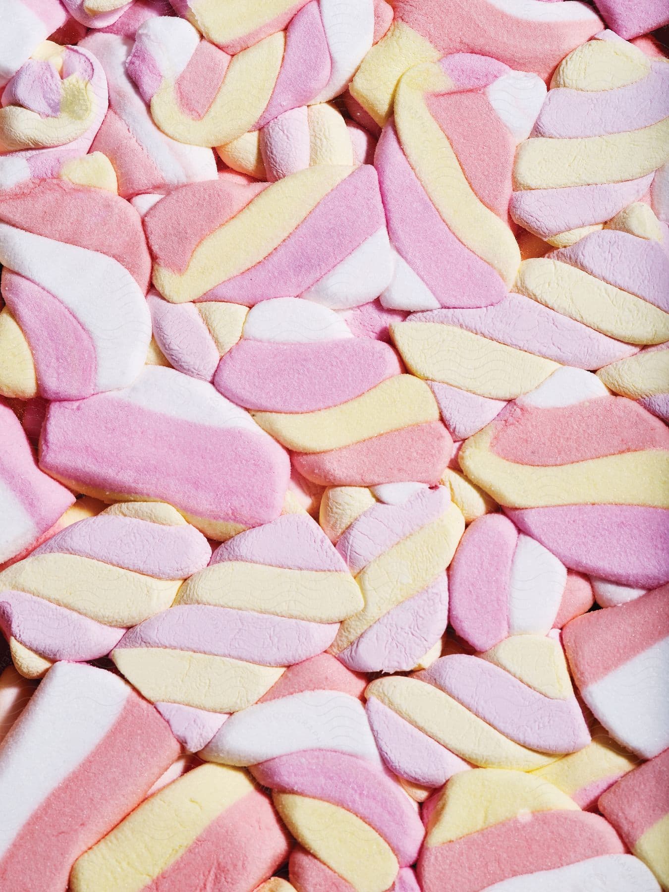 Multicolored marshmallow candy is smooshed together