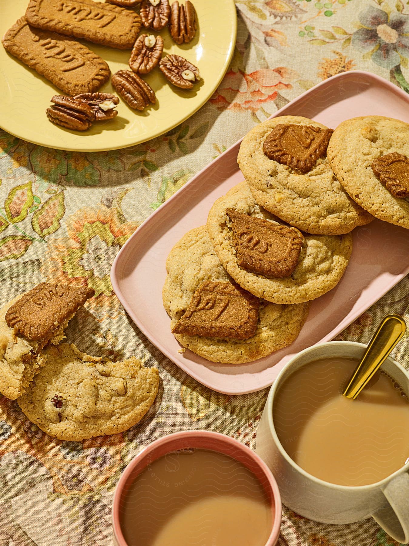 A collection of cookies pecans and coffee cups on a table