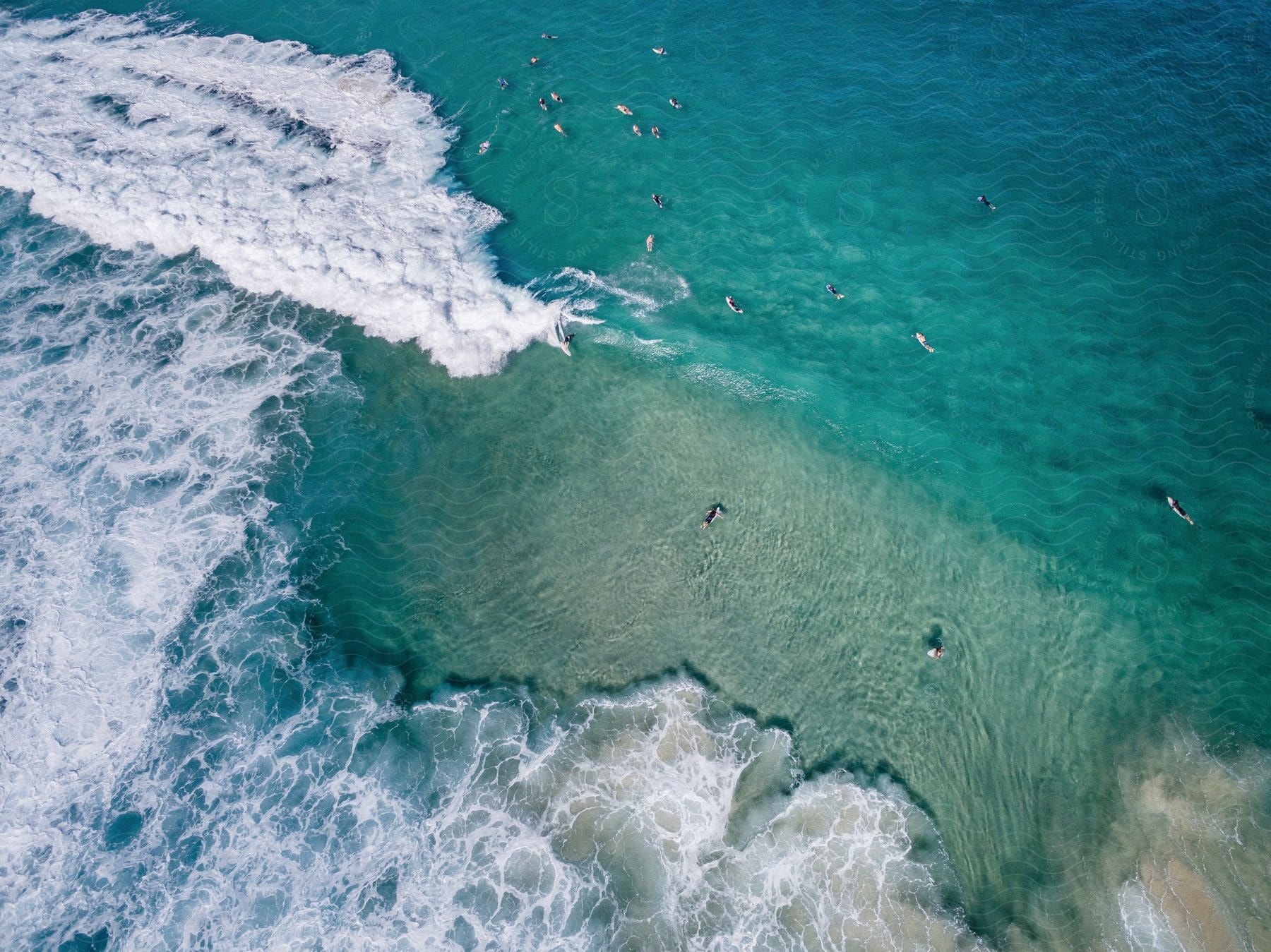 Surfers in ocean water seen from above