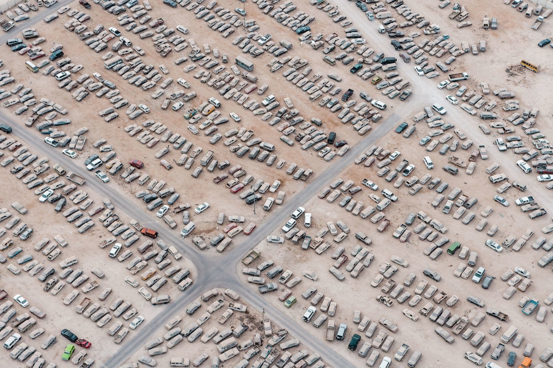 A parking lot filled with dirty cars