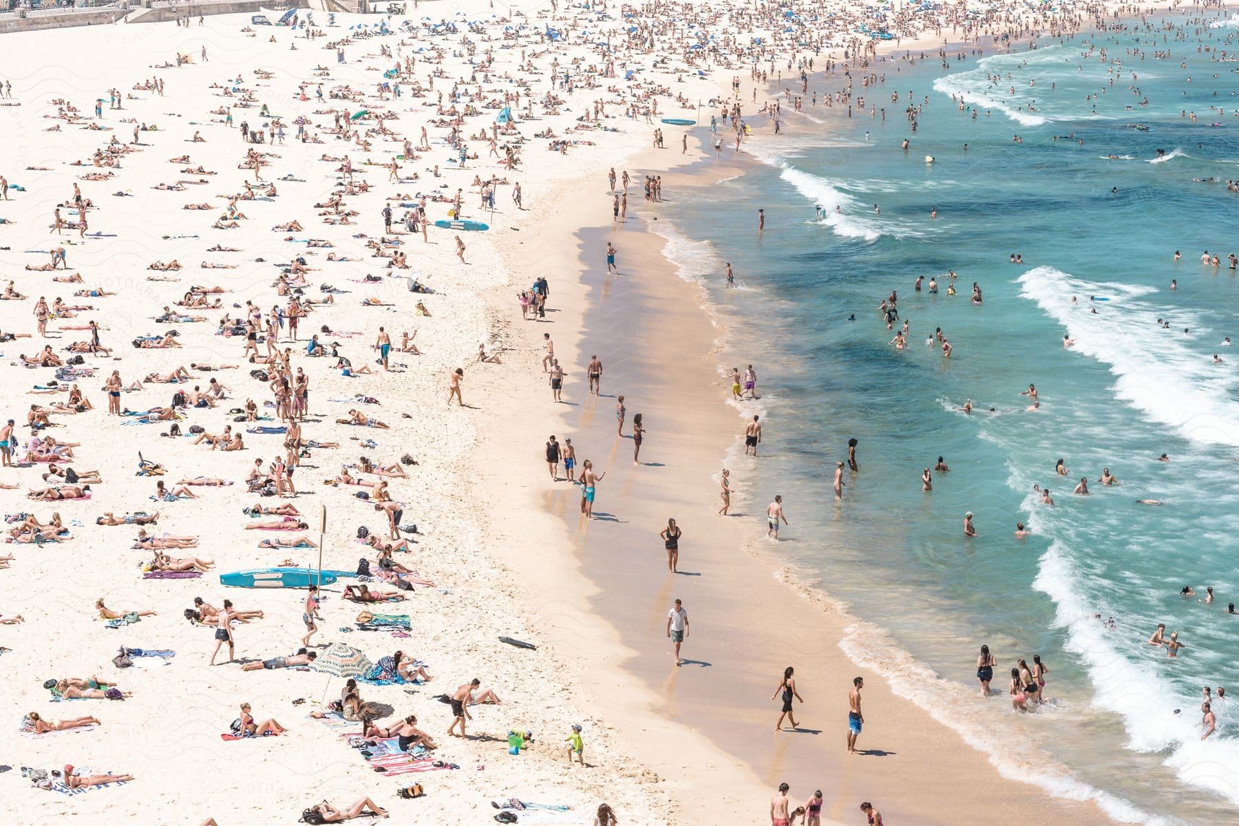 A crowded sandy beach with people enjoying the sun ocean and each others company