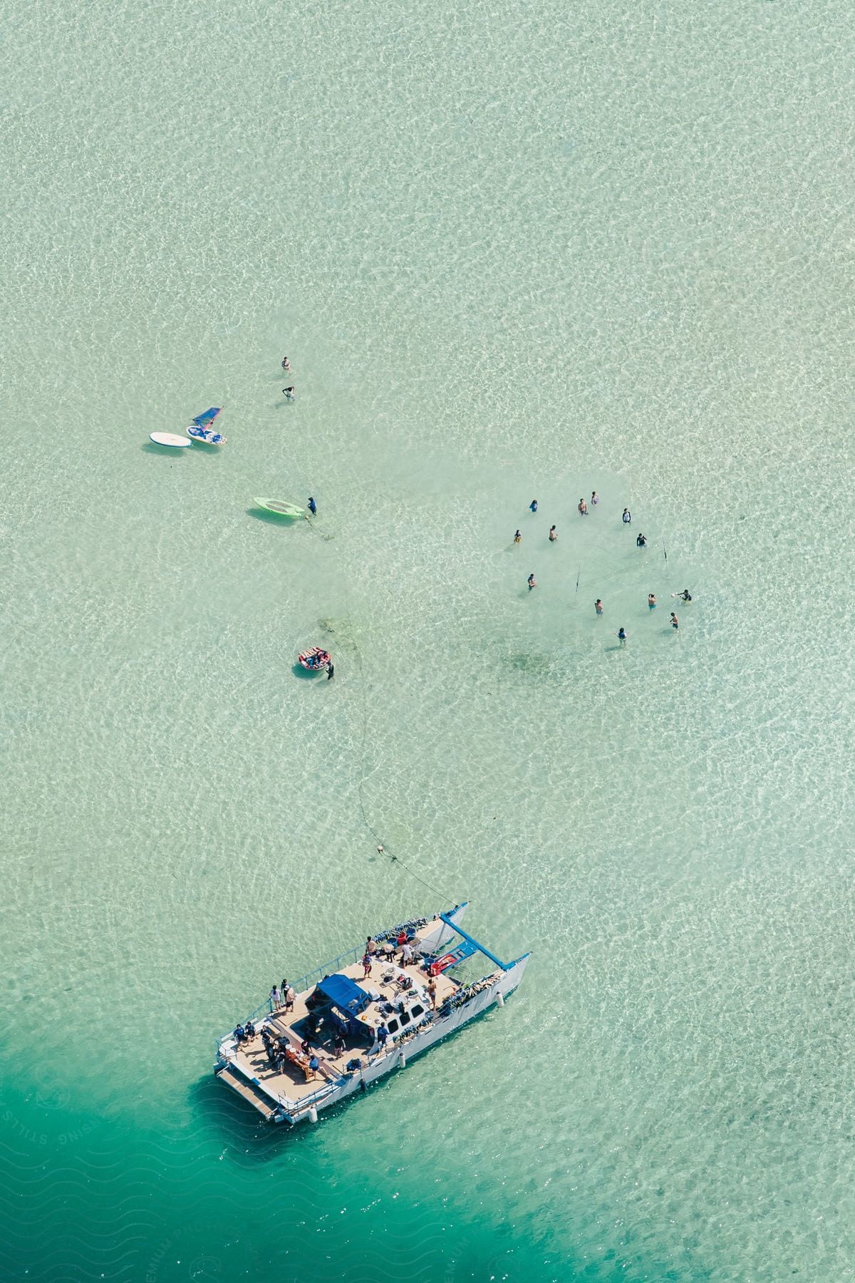 A clear sea with bathers and a boat seen from above