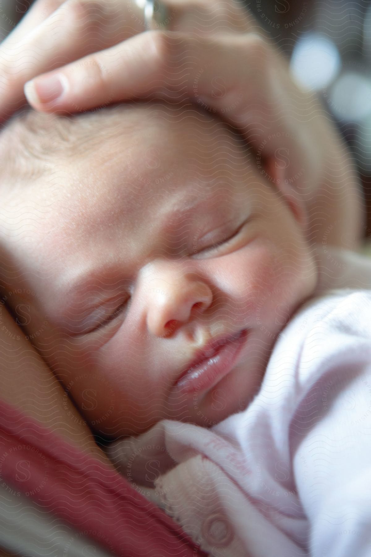 A woman holds her sleeping baby in her arms