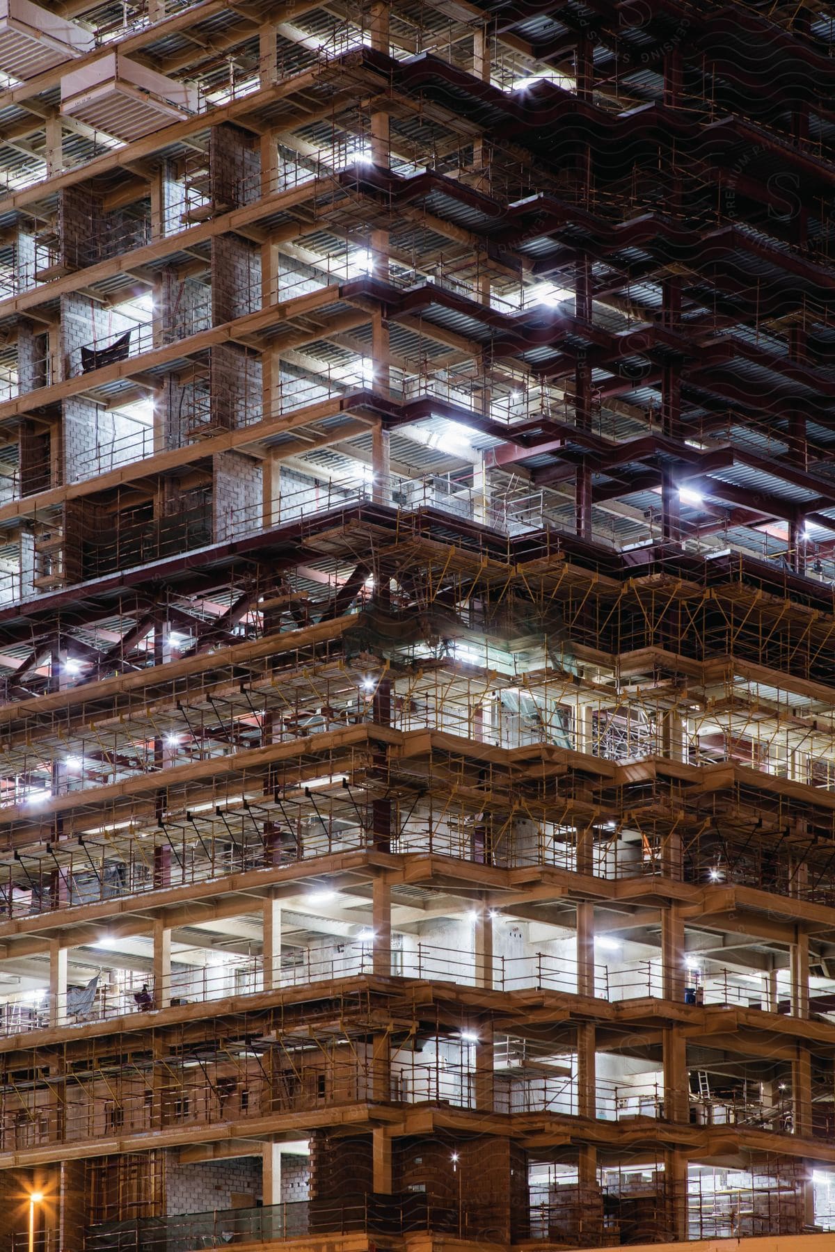 Unfinished high rise building seen from the ground at night