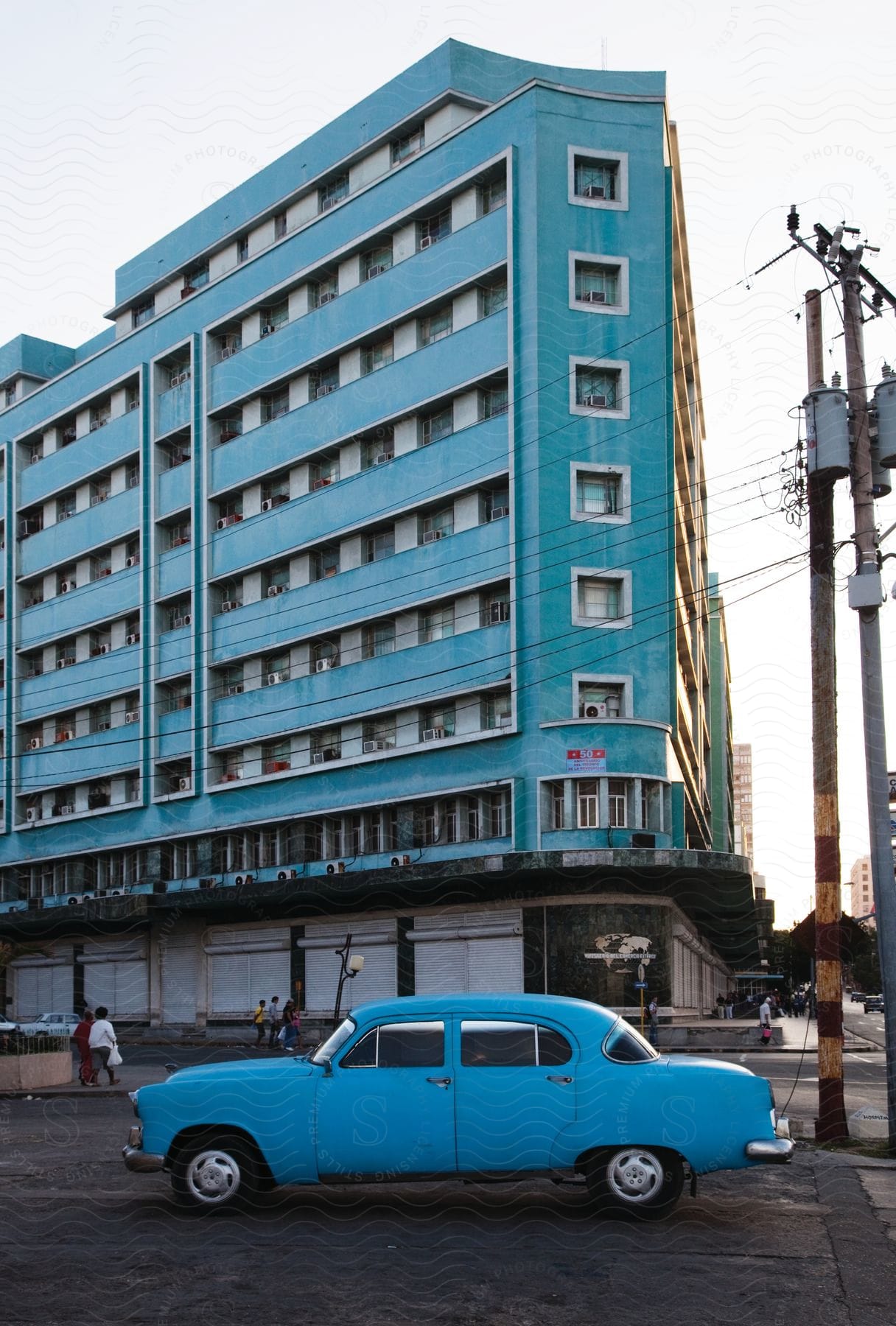 A vintage car parked in front of an apartment building