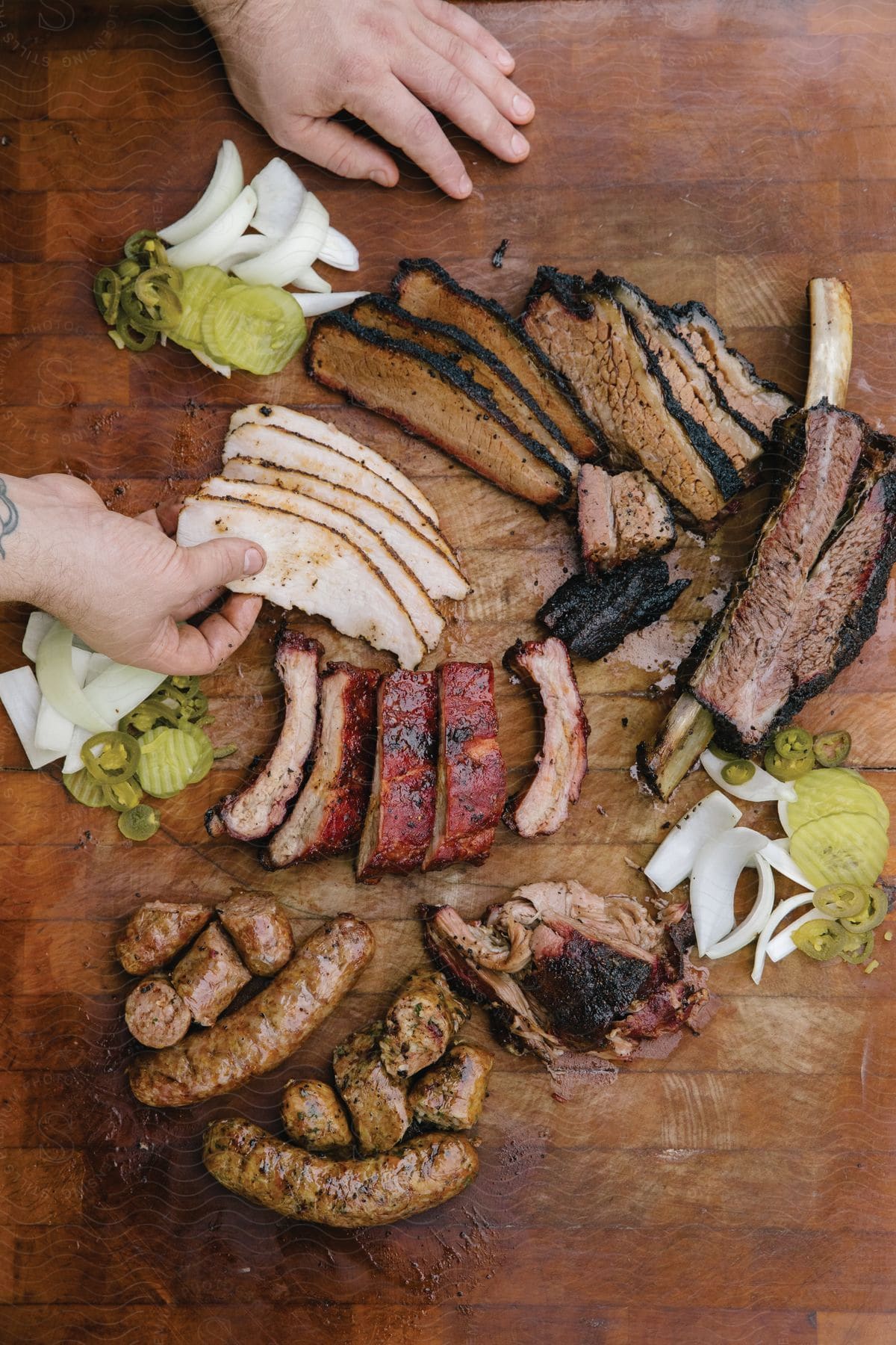 A pitmaster proudly displays smoked meats including sausage brisket beef ribs and smoked turkey with onions and pickles at a barbecue restaurant