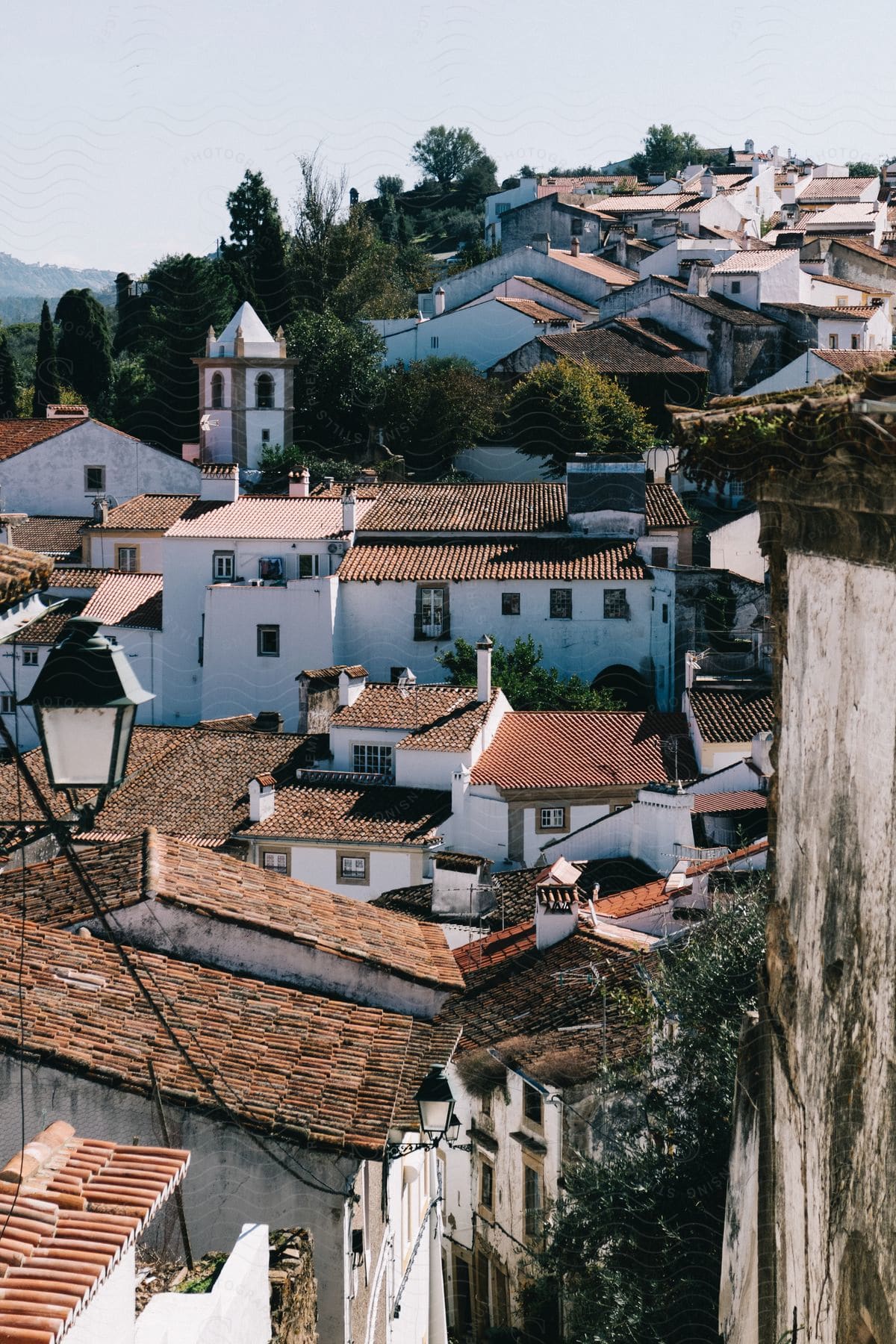 A village of spanish mission style homes built on a hillside with green mediterranean type trees