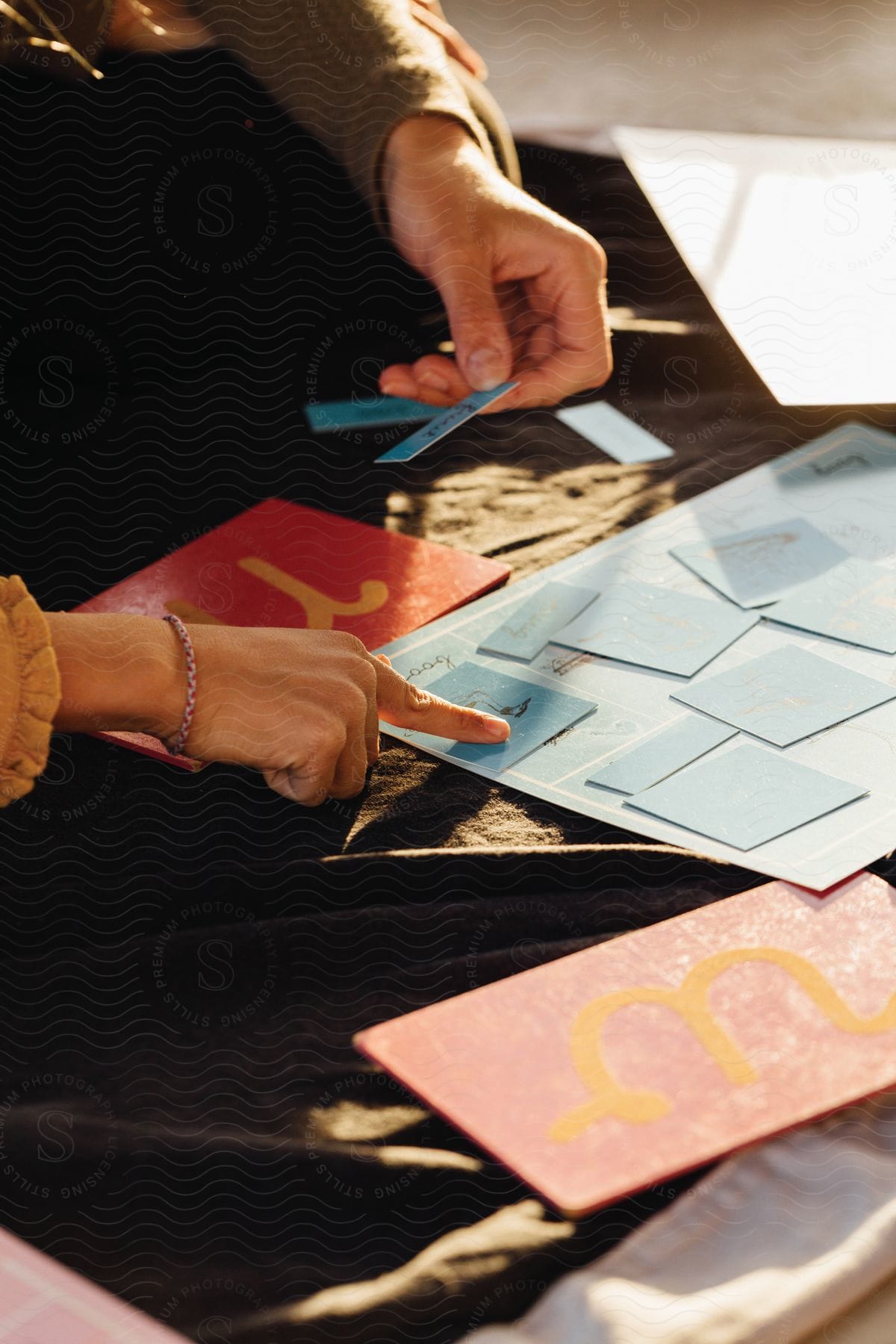 A male and a female artist are pointing at blue pieces of cardboard on a work table