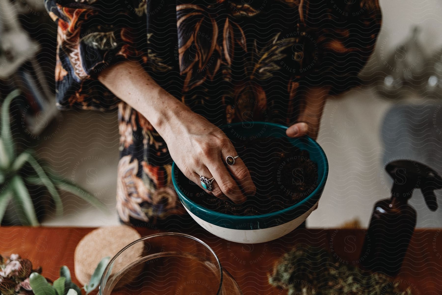 A woman prepares soil for planting in a bowl