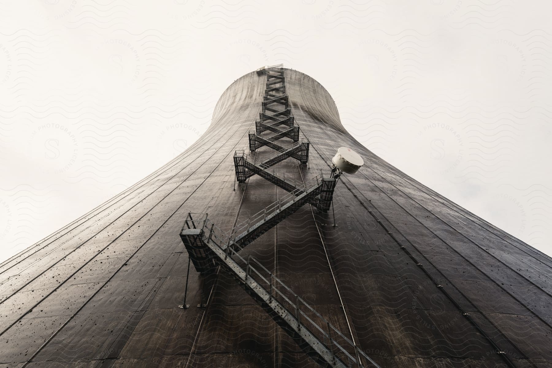 A black and white view of maintenance stairs leading up to the top of a nuclear cooling tower